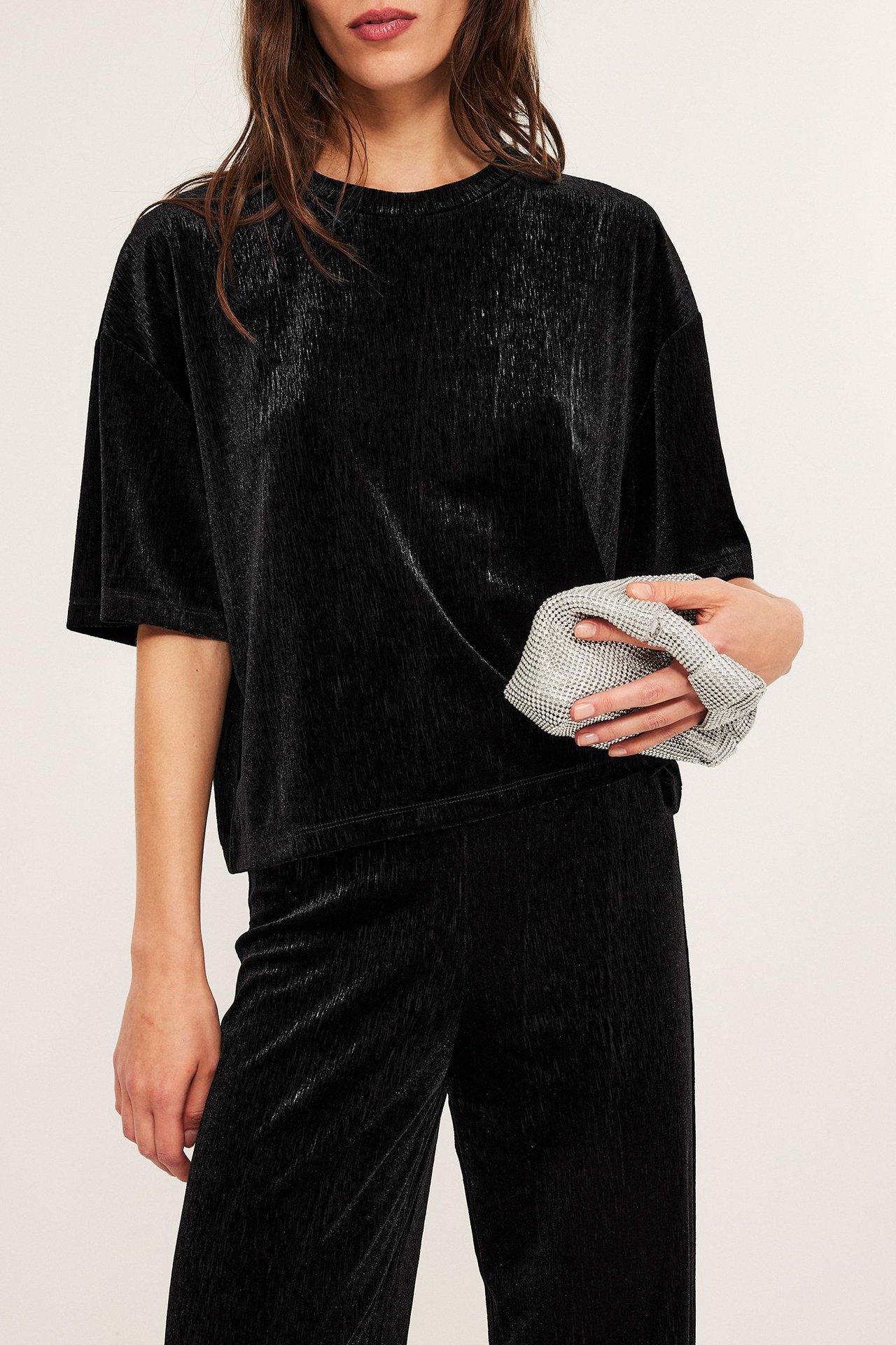 Sort løs passform velour-topp, kvinne med clutch-veske, frontvisning.