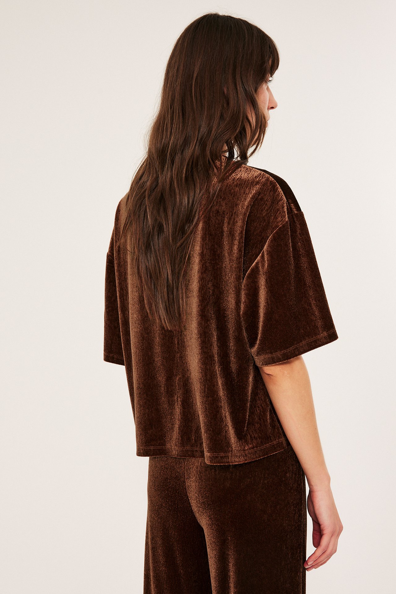 Kvinne i brun velour topp med løstsittende kort erme, forfra.