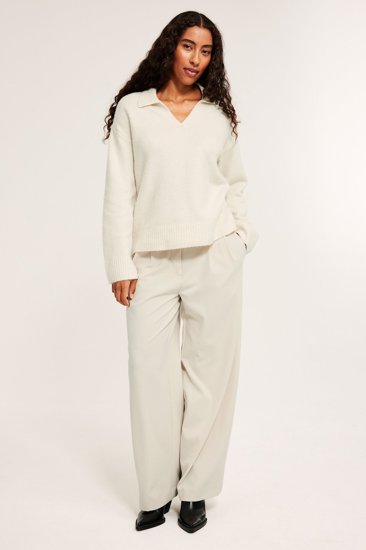 Mjuk ljusbeige stickad tröja med krage, mandens behagliga fit, nära kropp, används över skjorta.