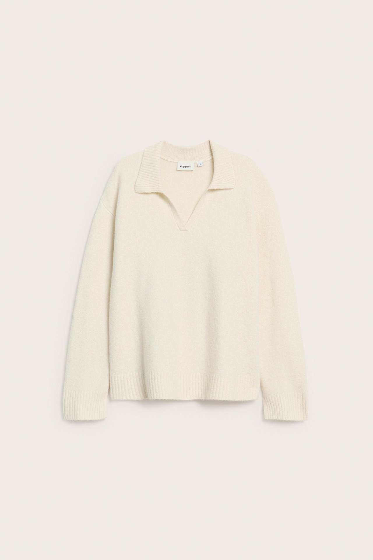 Framsida av en mjuk ljusbeige stickad pullovertröja med krage.