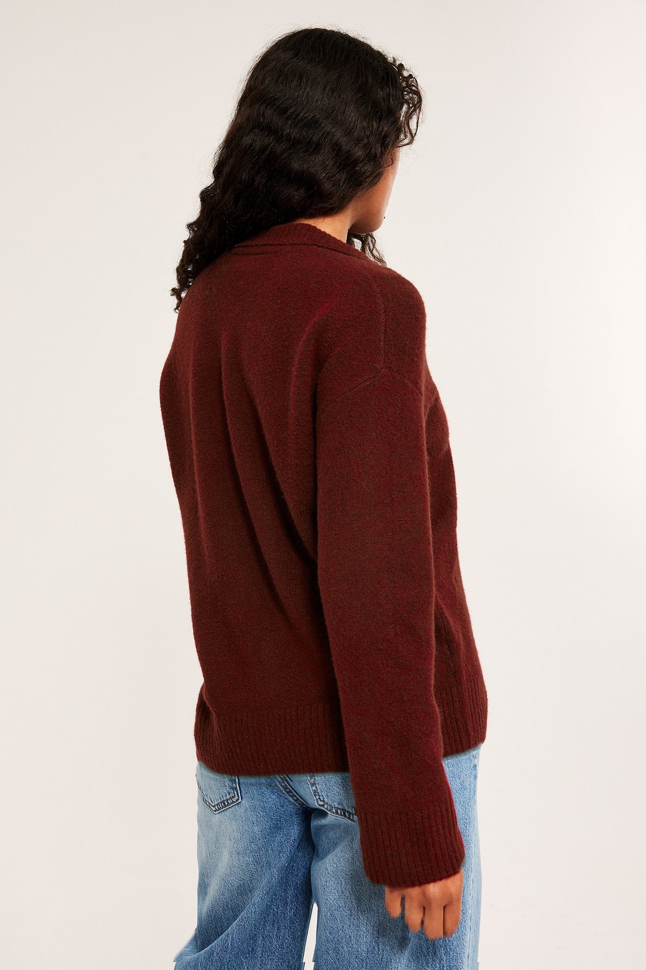 Mjuk röd melerad stickad pullover med krage på kvinna, sida vy.