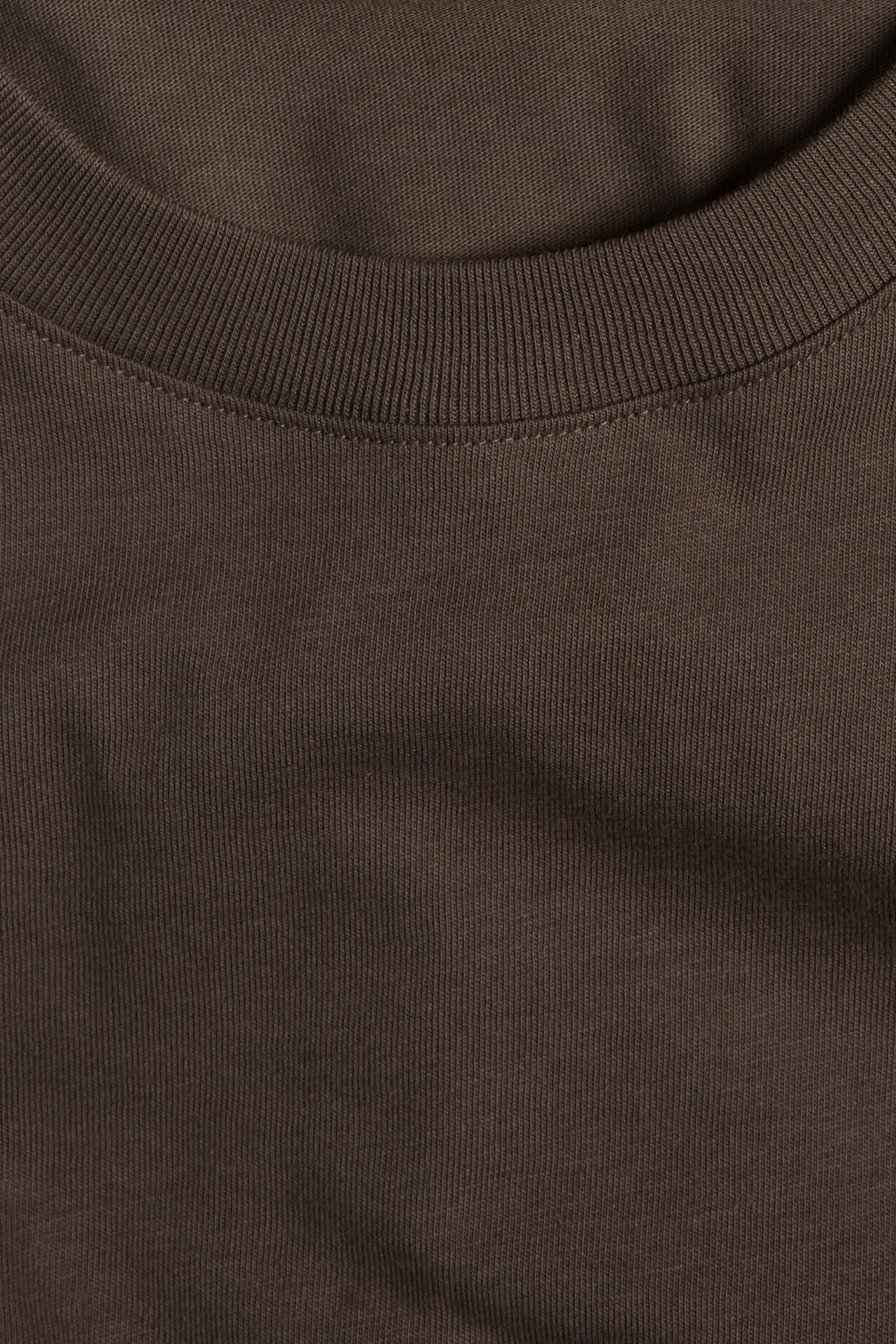 Zbliżenie na ciemnobrązowy bawełniany T-shirt z prążkowanym okrągłym dekoltem.