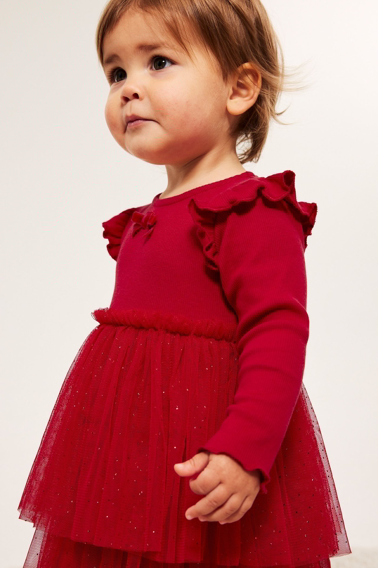 Rød julegenser med glitternett, fløyelsbånd, barnejente i rød kjole.