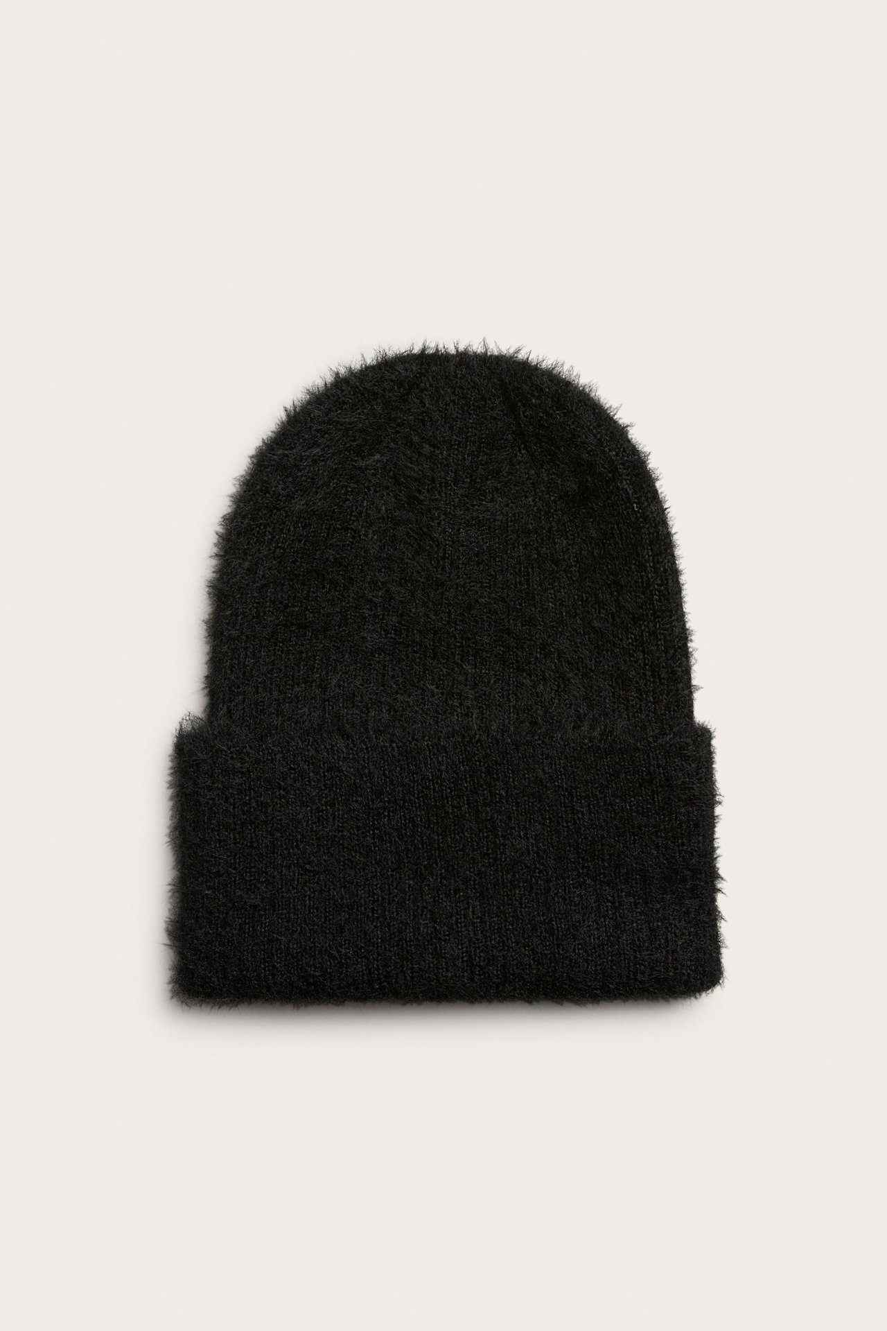 Widok z przodu czarnej, miękkiej, puszystej czapki z poliestru z wywiniętym brzegiem.