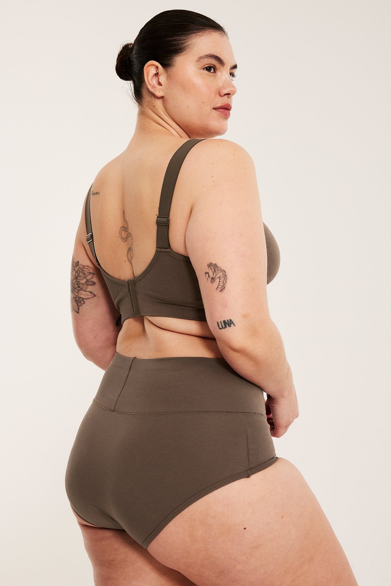 Widok z tyłu kobiety w ciemnobrązowych bawełnianych figach hipster, szeroki pas, pasujący biustonosz.