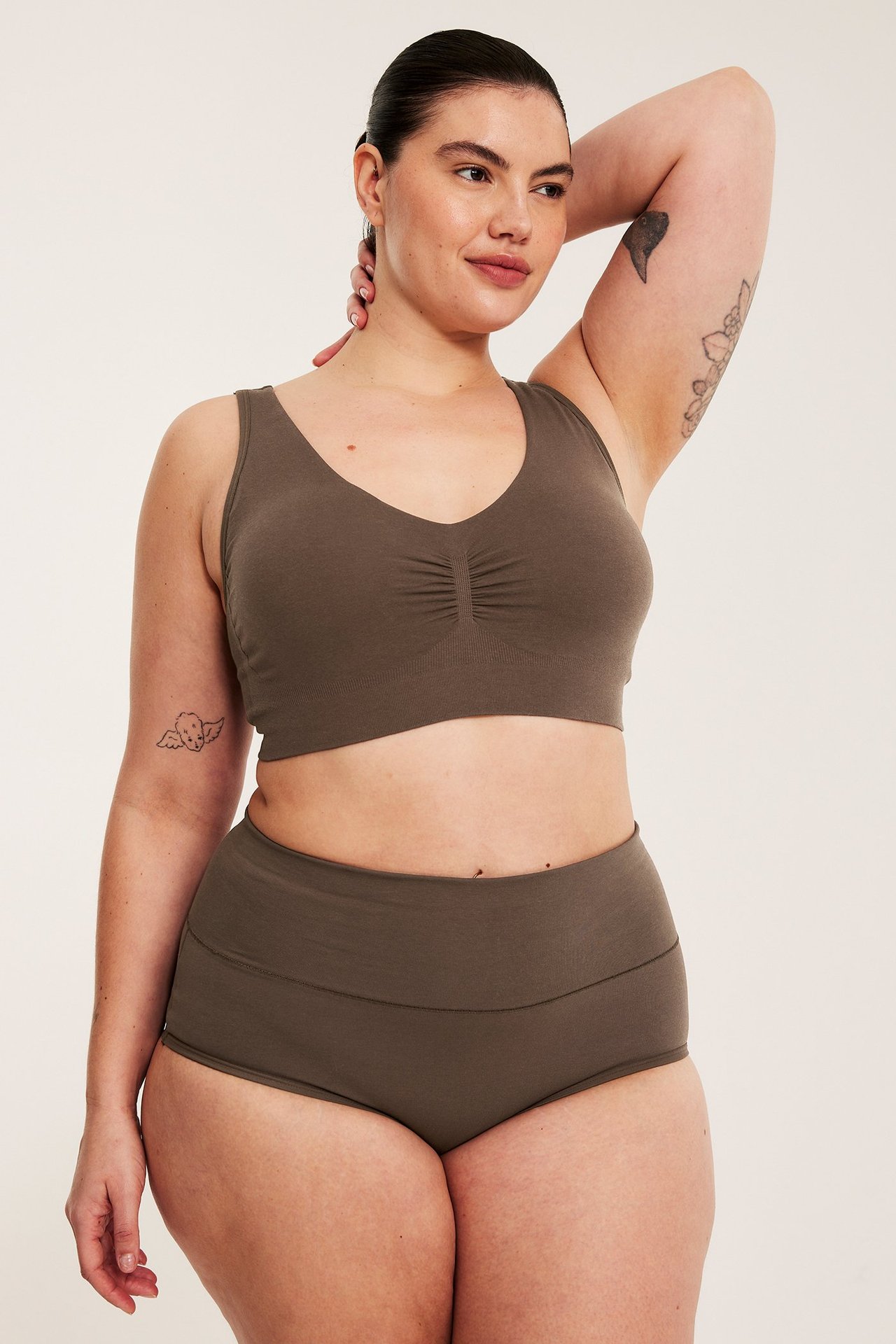 Frontbilde av en kvinne i mørkebrune, myke bomullshippstertruser og en matchende bralette.