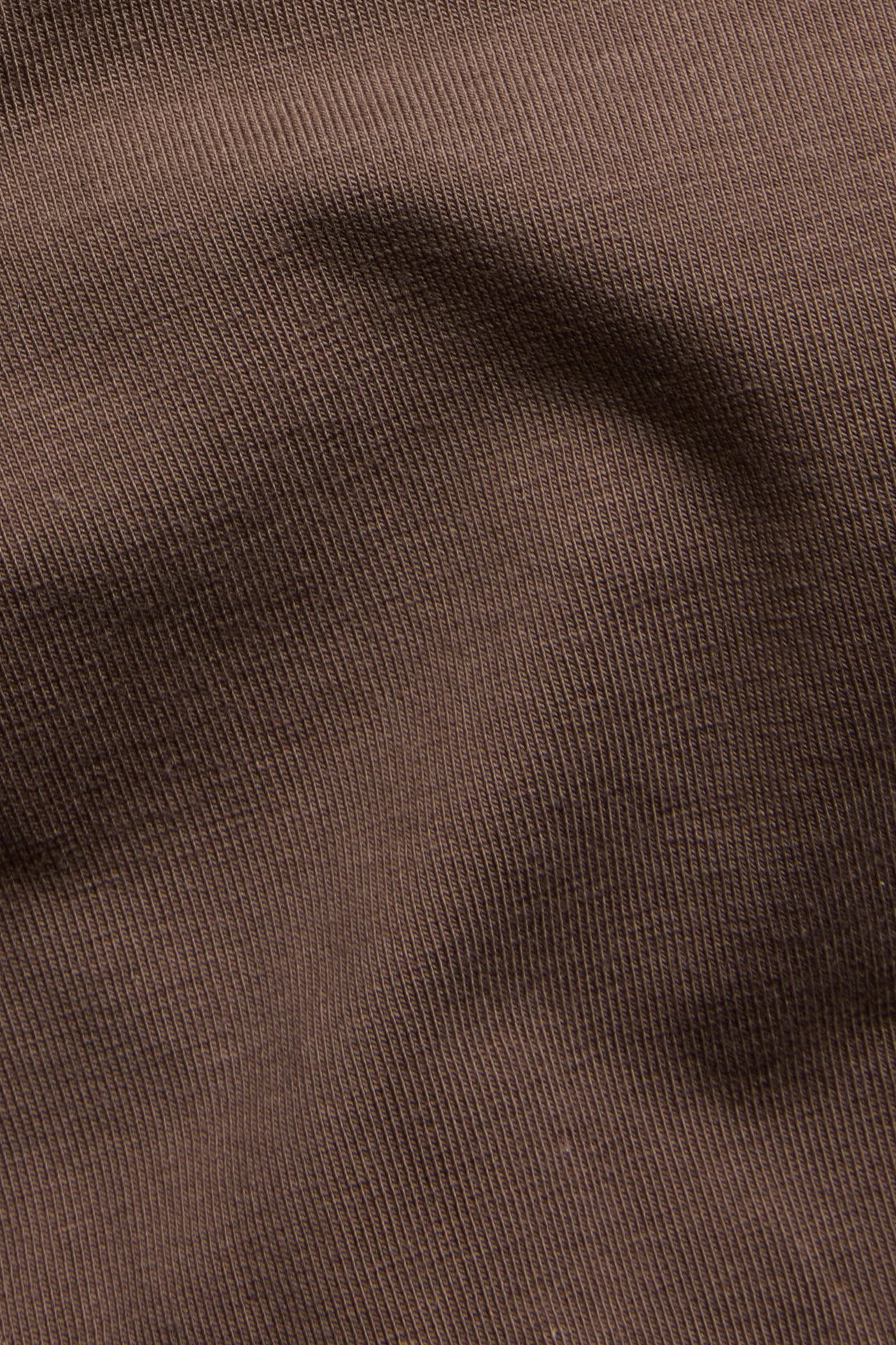 Lähikuva tummanruskeasta ribatusta puuvillakankaasta stringihousuihin.