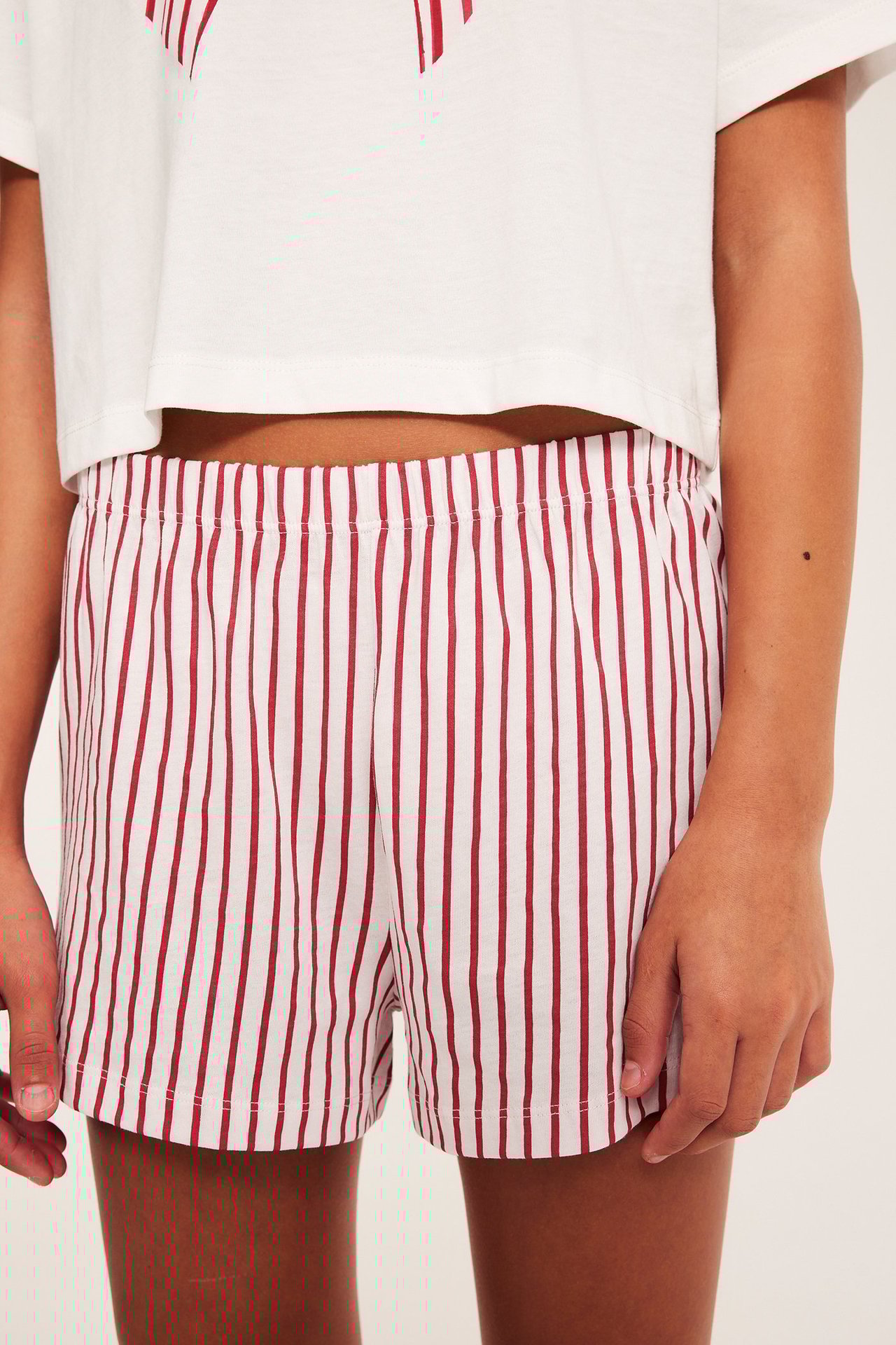 Lasten lyhythihainen pyjama, offwhite väri ja edessä kuvio, raidalliset shorts.