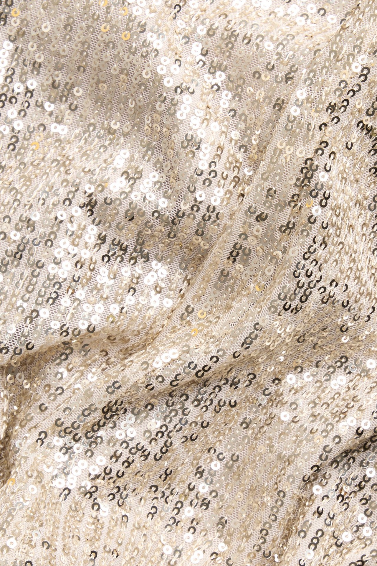 Zbliżenie na cekinowy materiał, błyszczący z małymi złotymi cekinami tworzącymi brokatowy wzór.