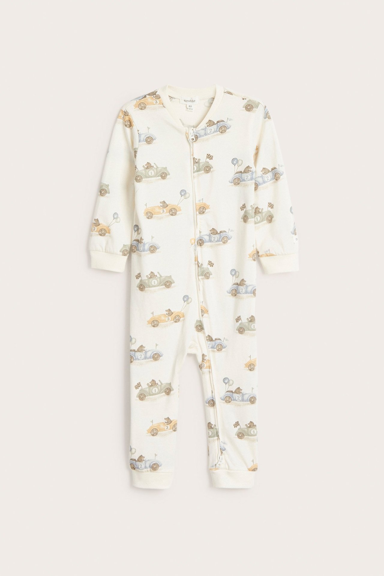 Frontvy av en offwhite baby-pyjamas i trikå med björn- och bilmönster, med tvåvägsdragkedja.