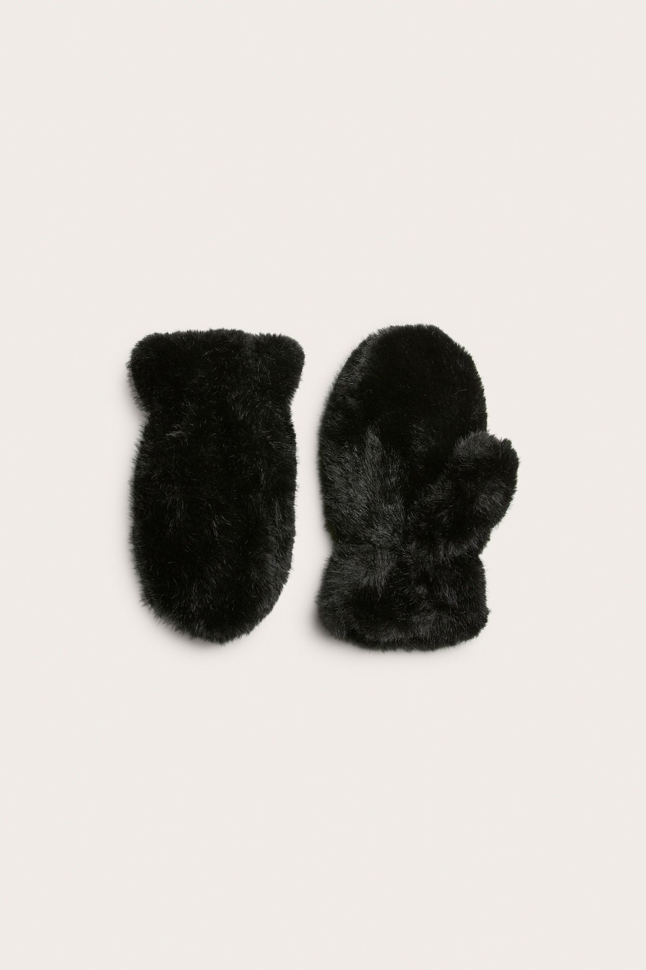 Widok z góry na dwie czarne, futrzane rękawiczki z fakturą.