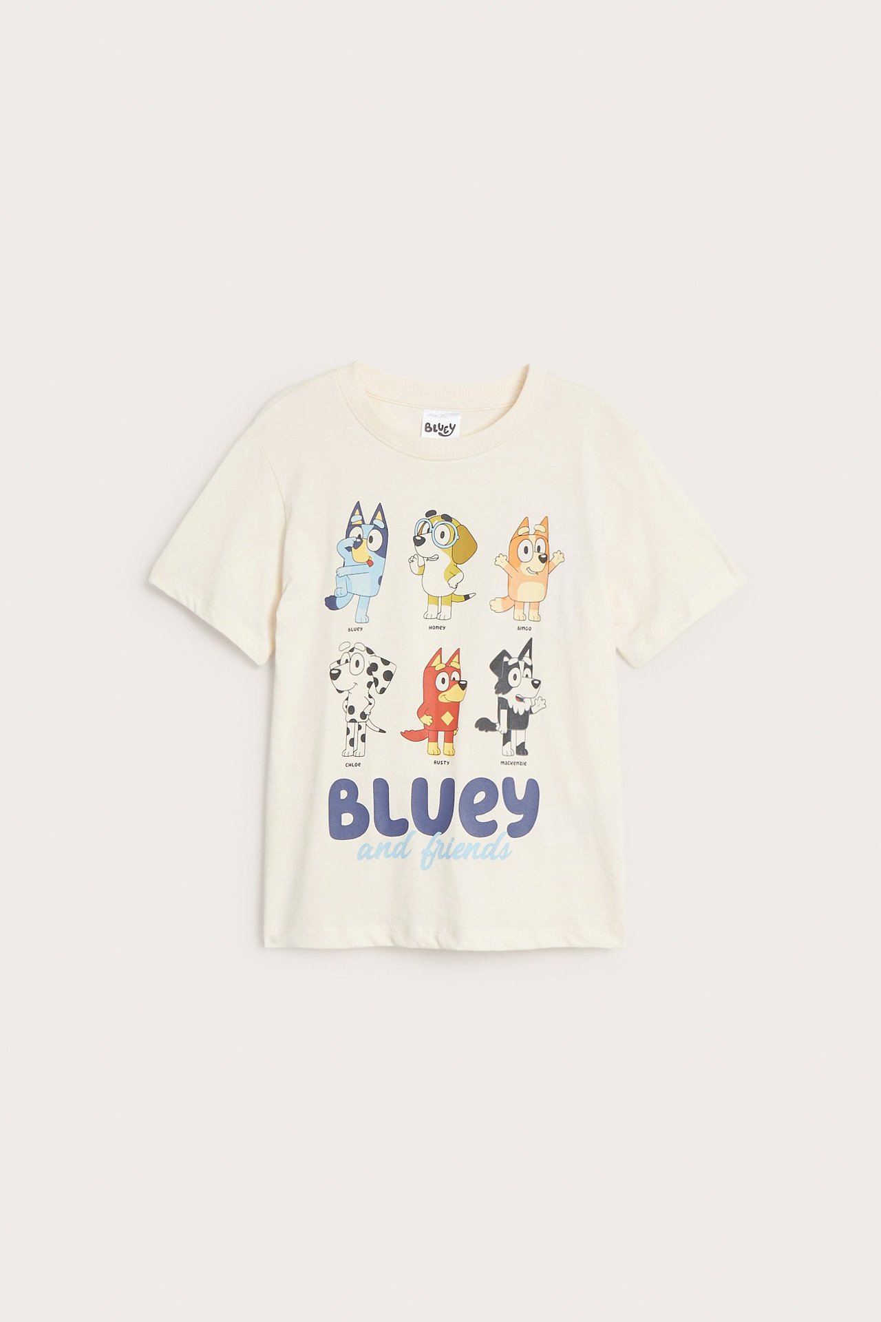 Framsida av en ljusbeige t-shirt i bomull för barn med stort Bluey och vänner-tryck.