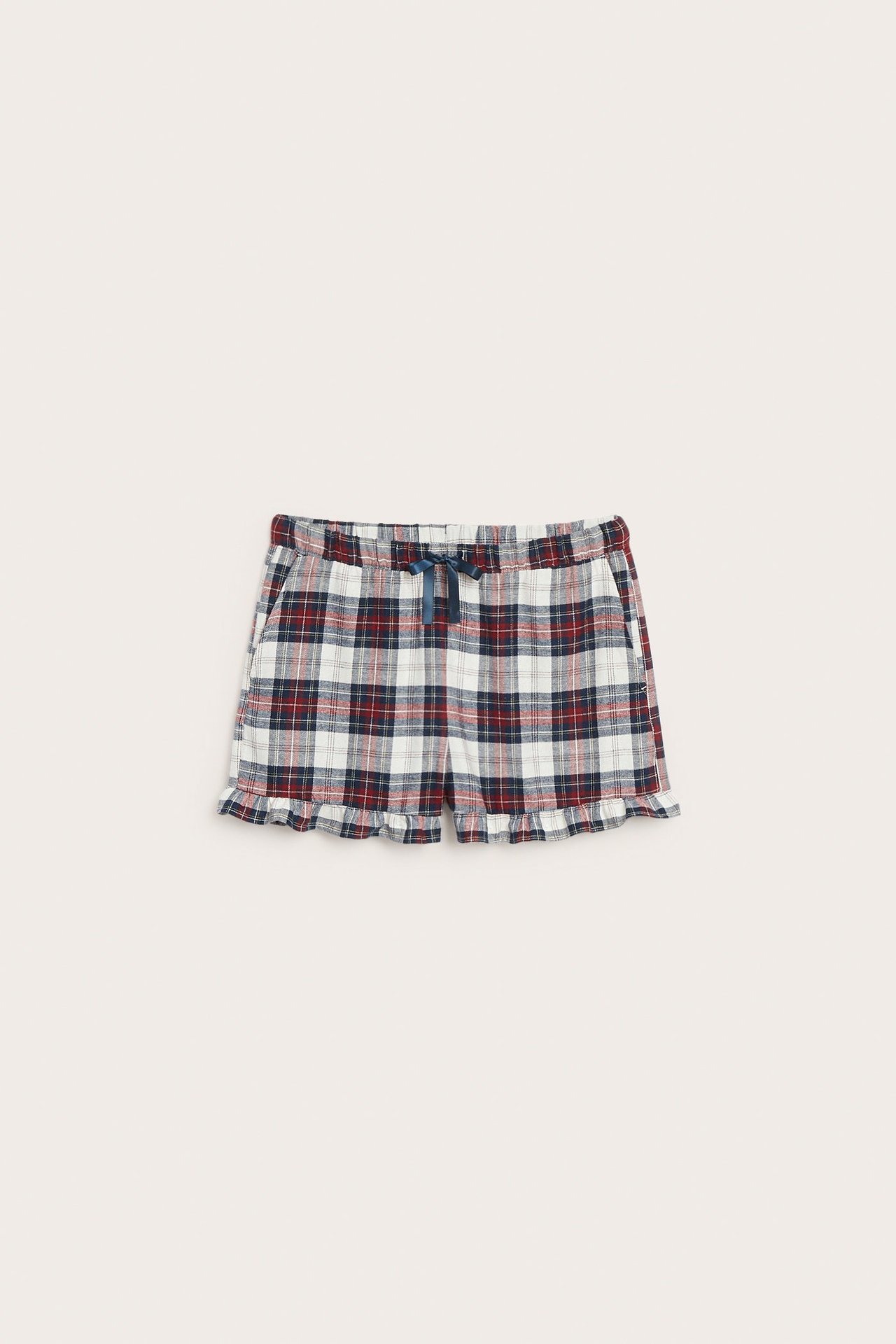 Forfra: Rutete pyjamasshorts i bomull med mørkeblå, rød, hvit farge, strikk i midjen og rysjekant.