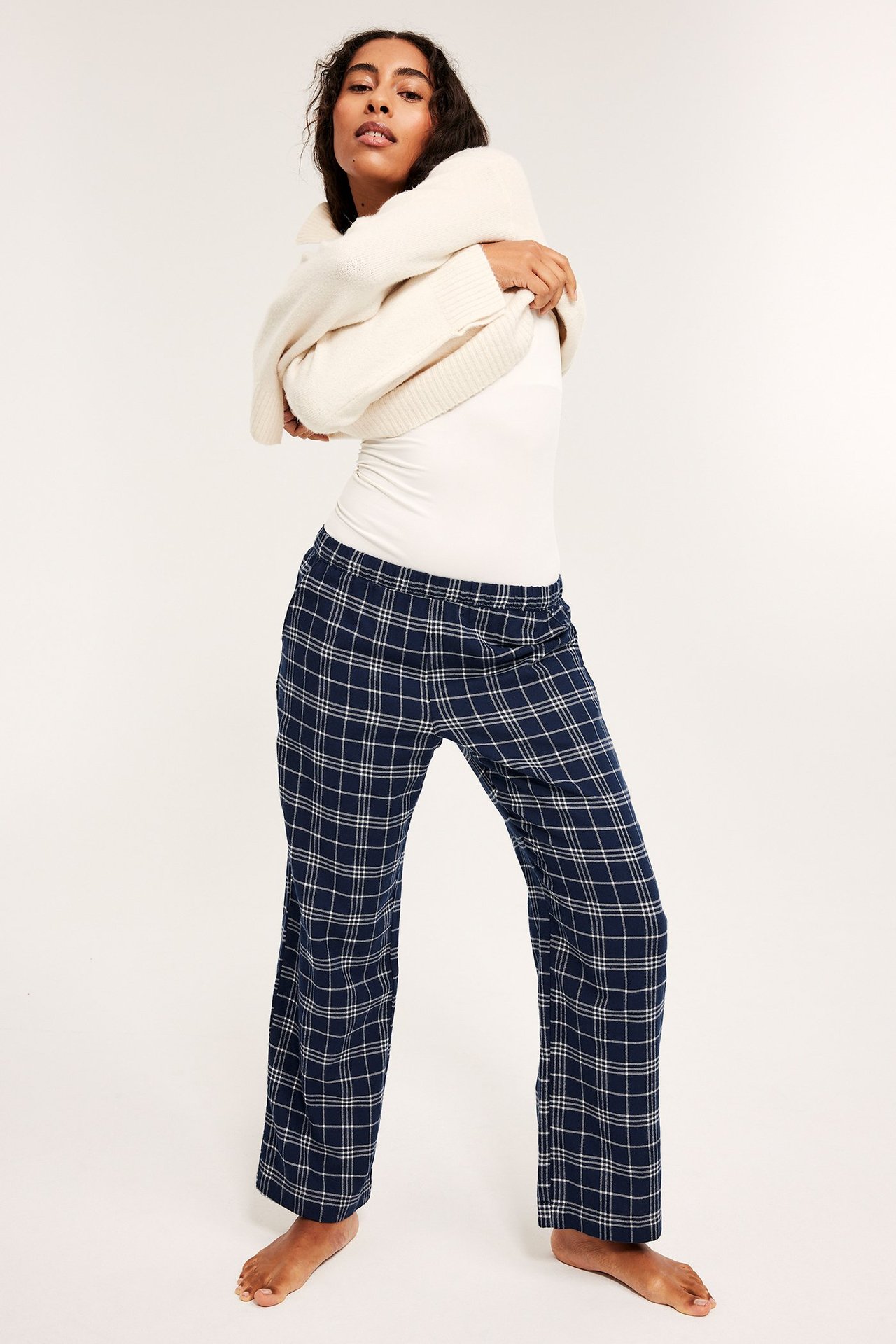 Naismalli valkoinen toppi ja tummansiniset ruudulliset flanellipyjama-housut, edestä.