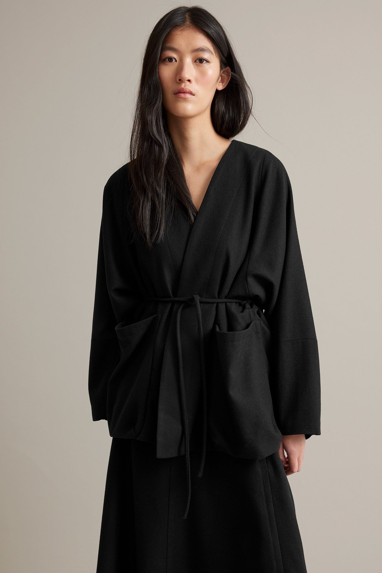 Nainen musta villasekoite takki, vuorattu, vyö, ei lapaa, etunäkymä.