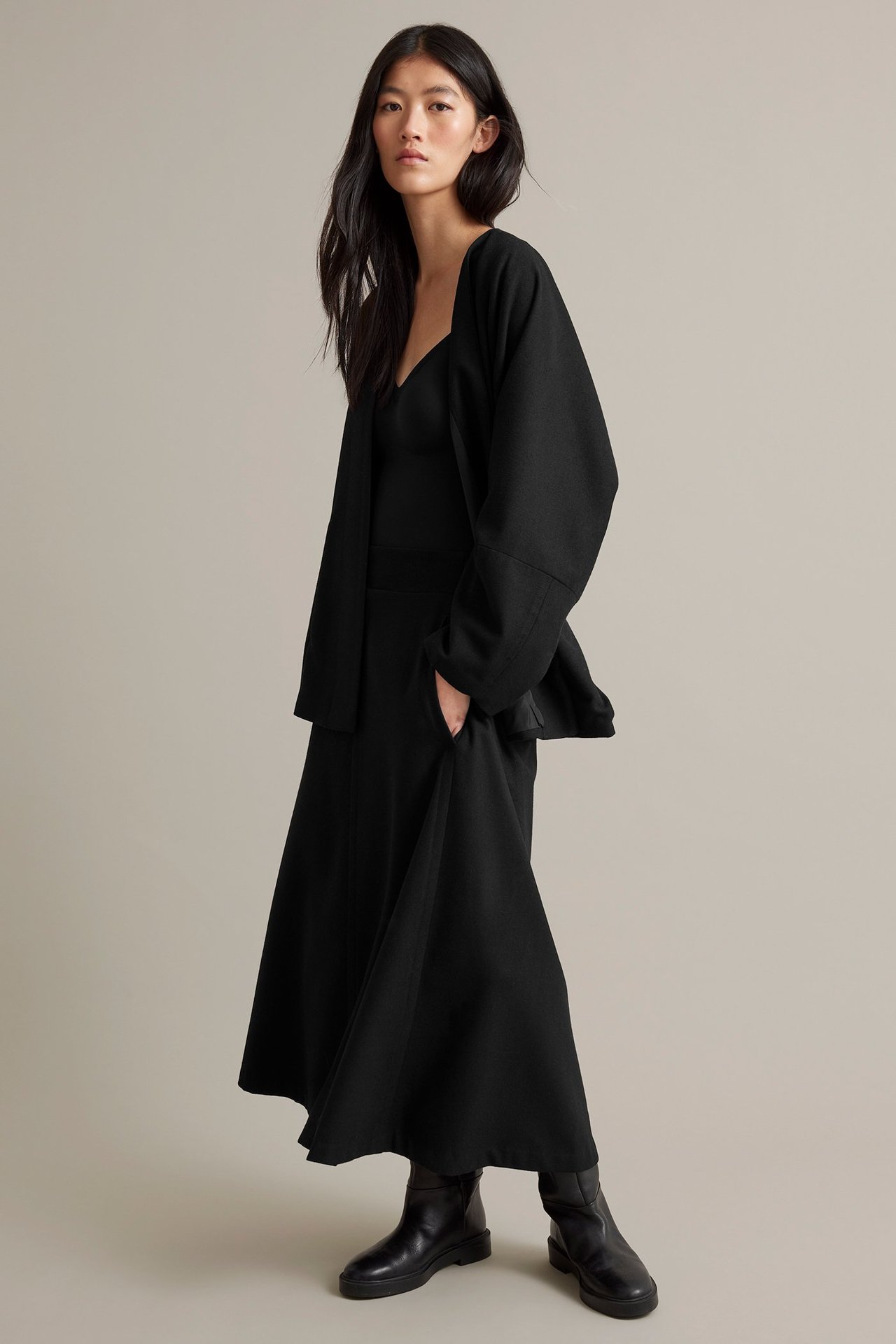 Nainen mustassa villasekoitekappareessa ilman reunoja, vyöllä, vuorellinen, etuala.