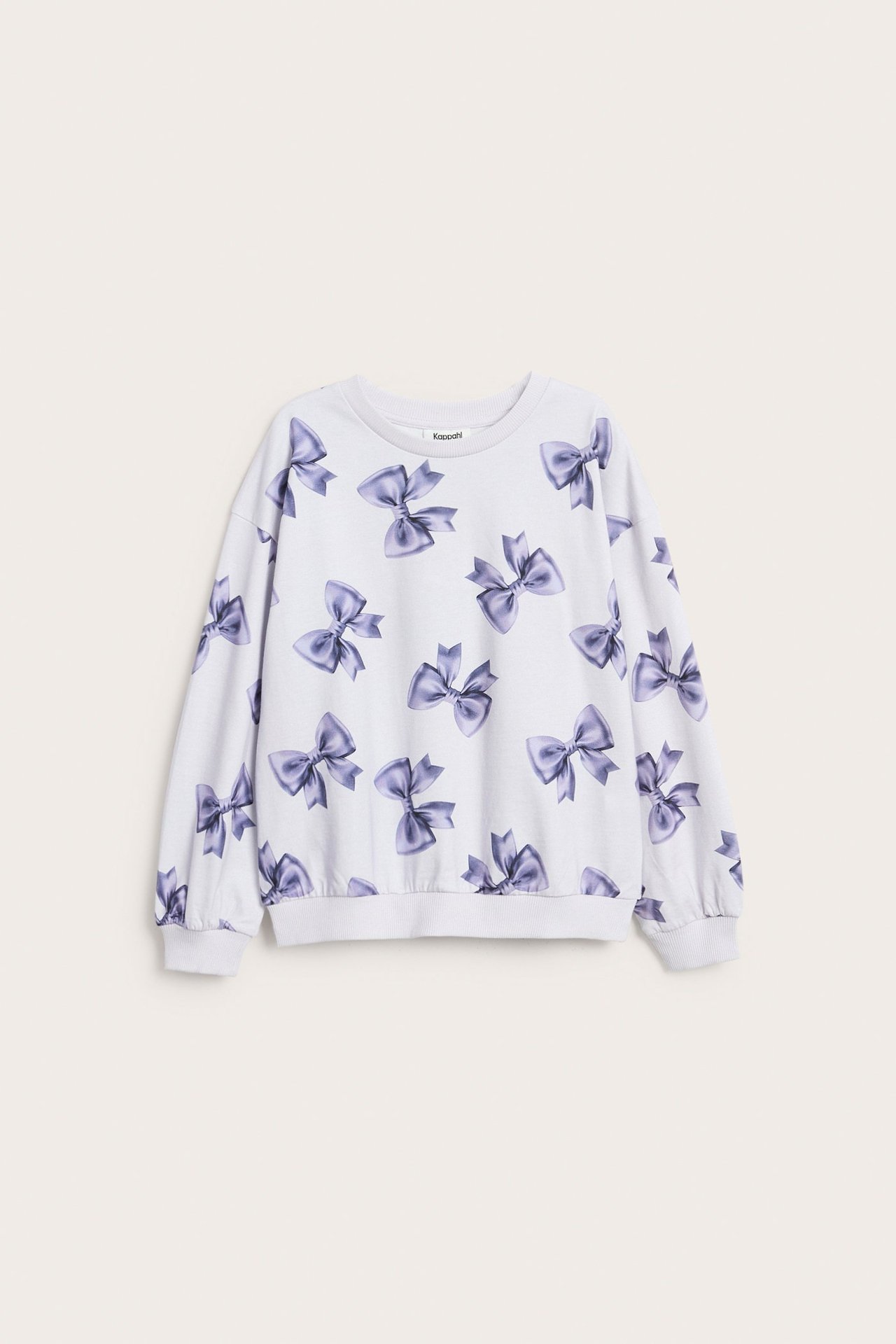 Pitkähihainen lasten paita valkoisena puuvillaa ja violetteja rusettiä.