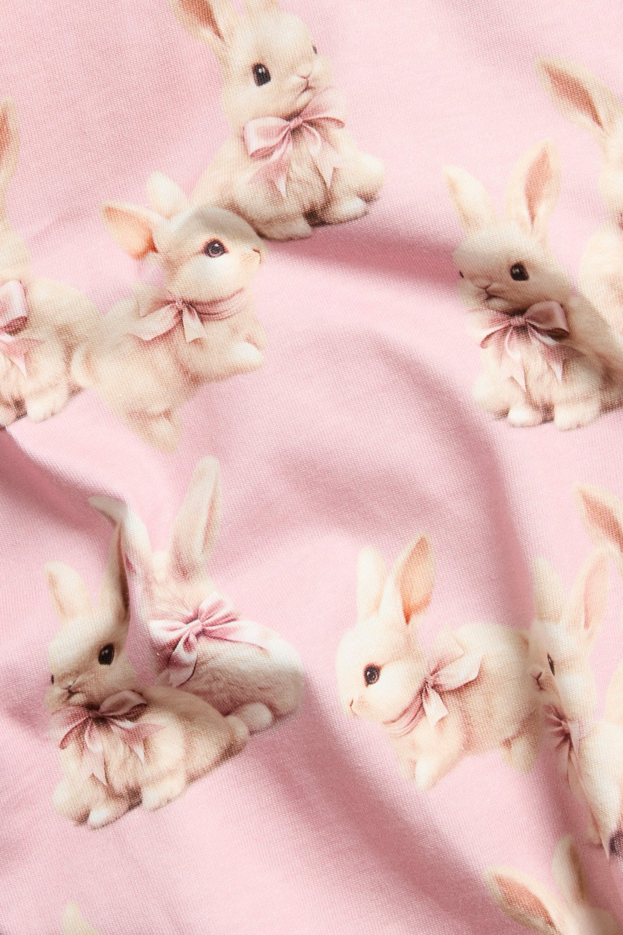 Jasnoróżowa koszulka z długim rękawem, z zajęczymi wzorami, dla dzieci, widok z przodu.