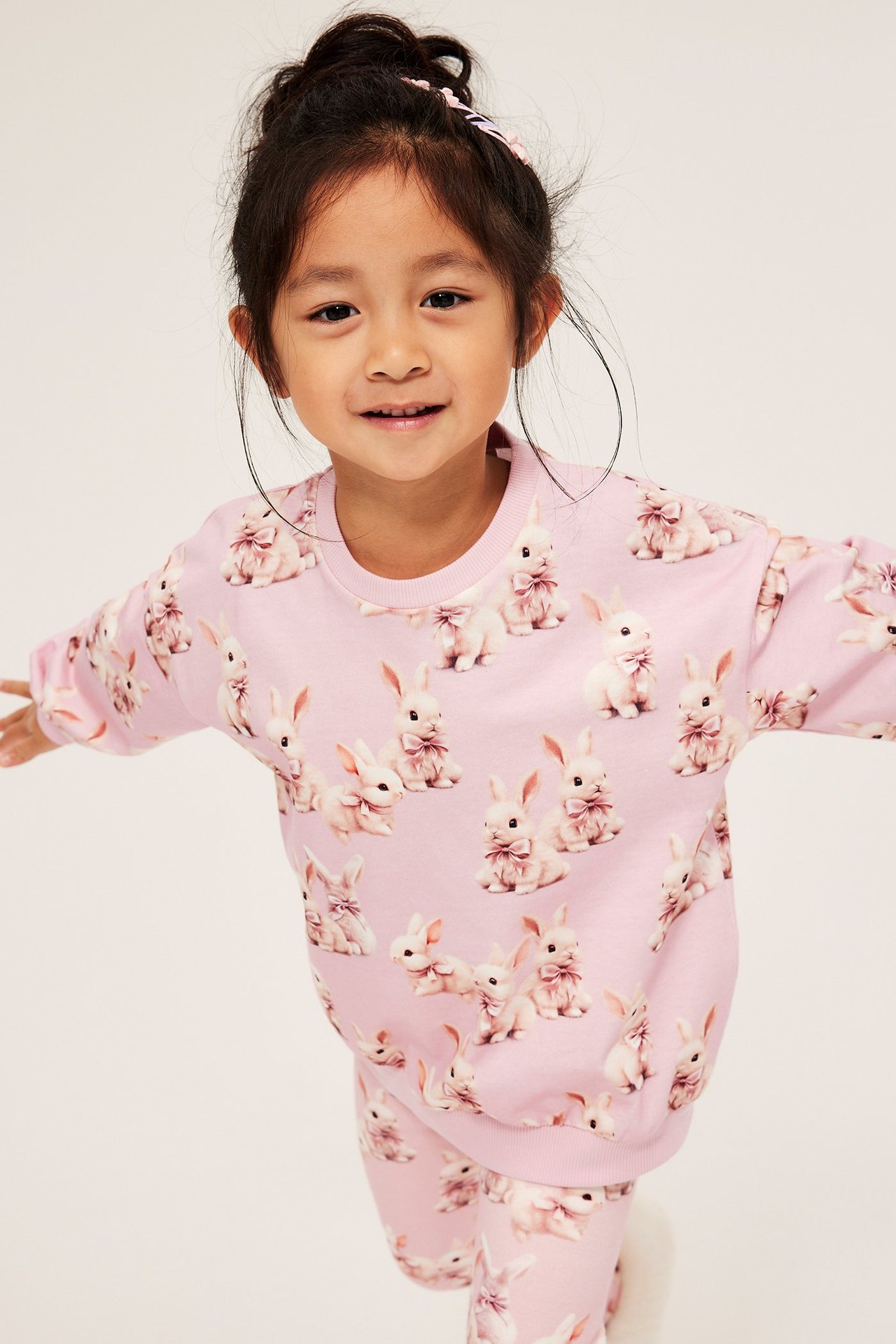 Långärmad barn-topp i ljusrosa med kaninmönster, ribb i hals, ärmslut och nederkant.