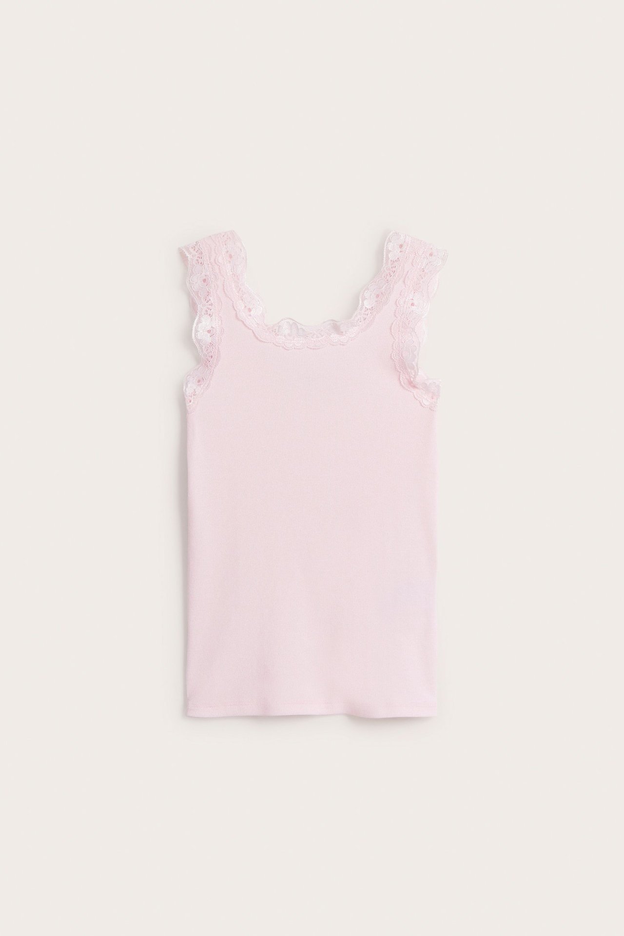 Widok z przodu: Jasnoróżowy, prążkowany top dziecięcy z delikatną koronką przy dekolcie i pachach.
