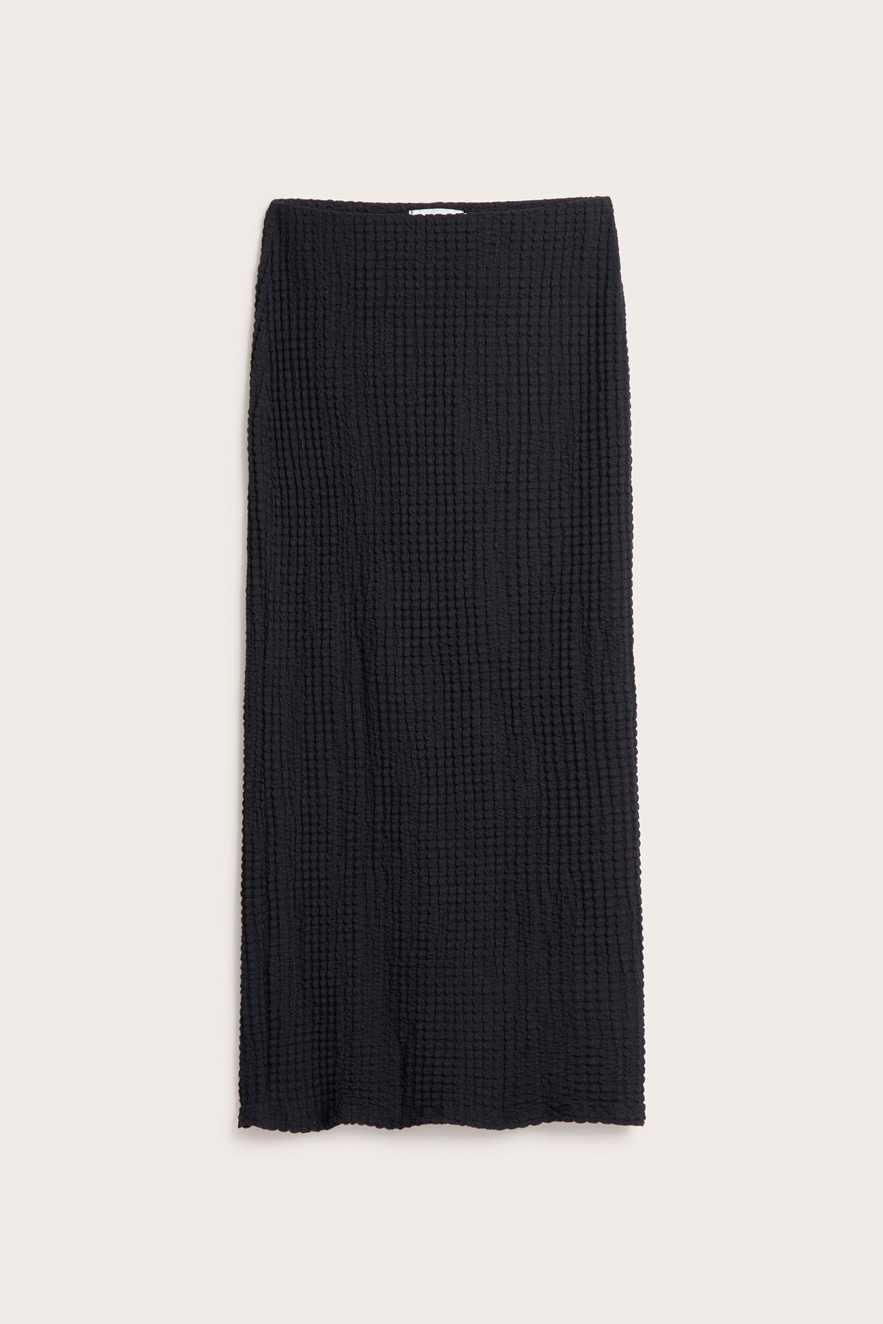 Widok z przodu długiej, czarnej, strukturalnej spódnicy z elastyczną talią.