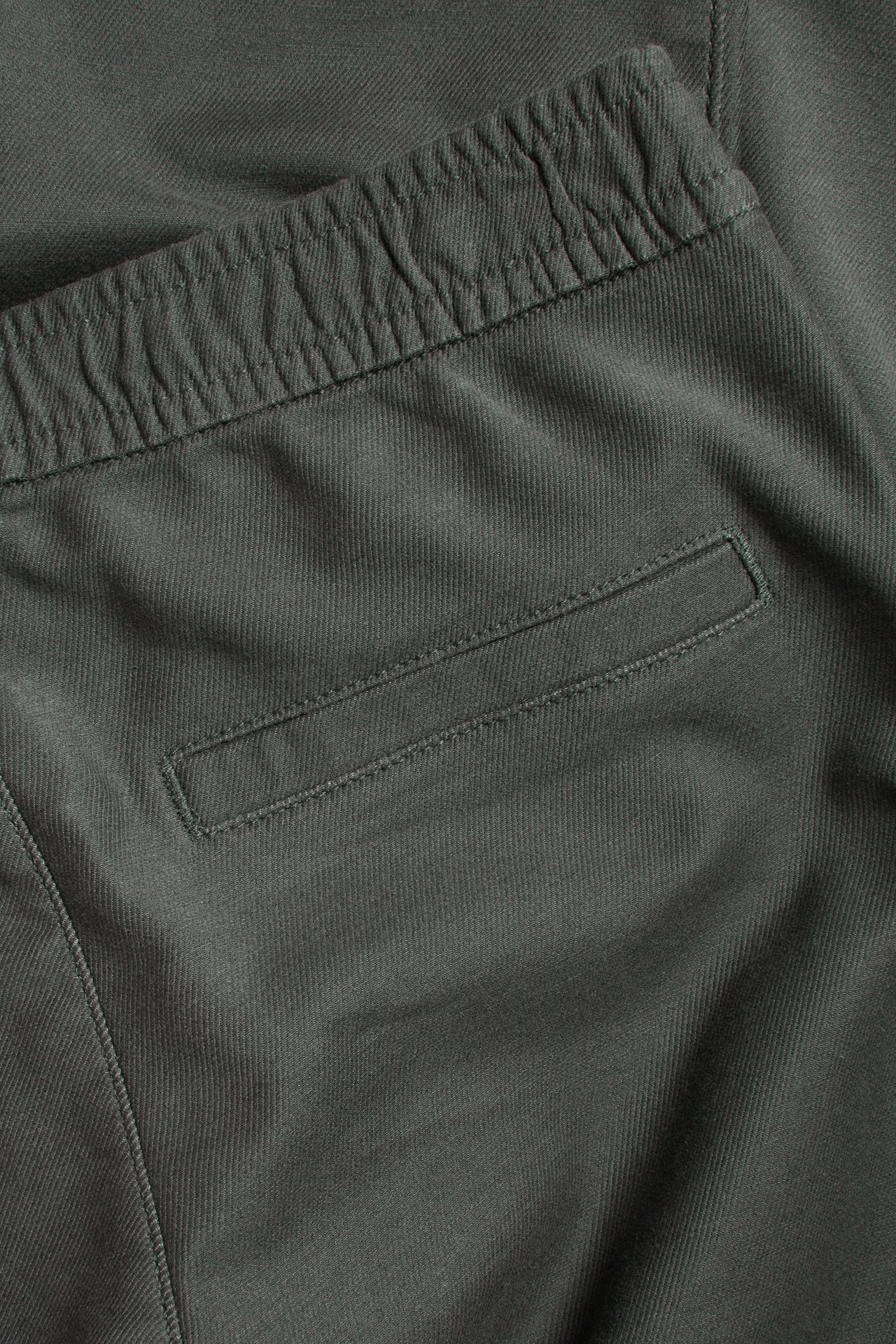 Zbliżenie czarnych chinosów dziecięcych z elastycznym pasem i naszytą tylną kieszenią.