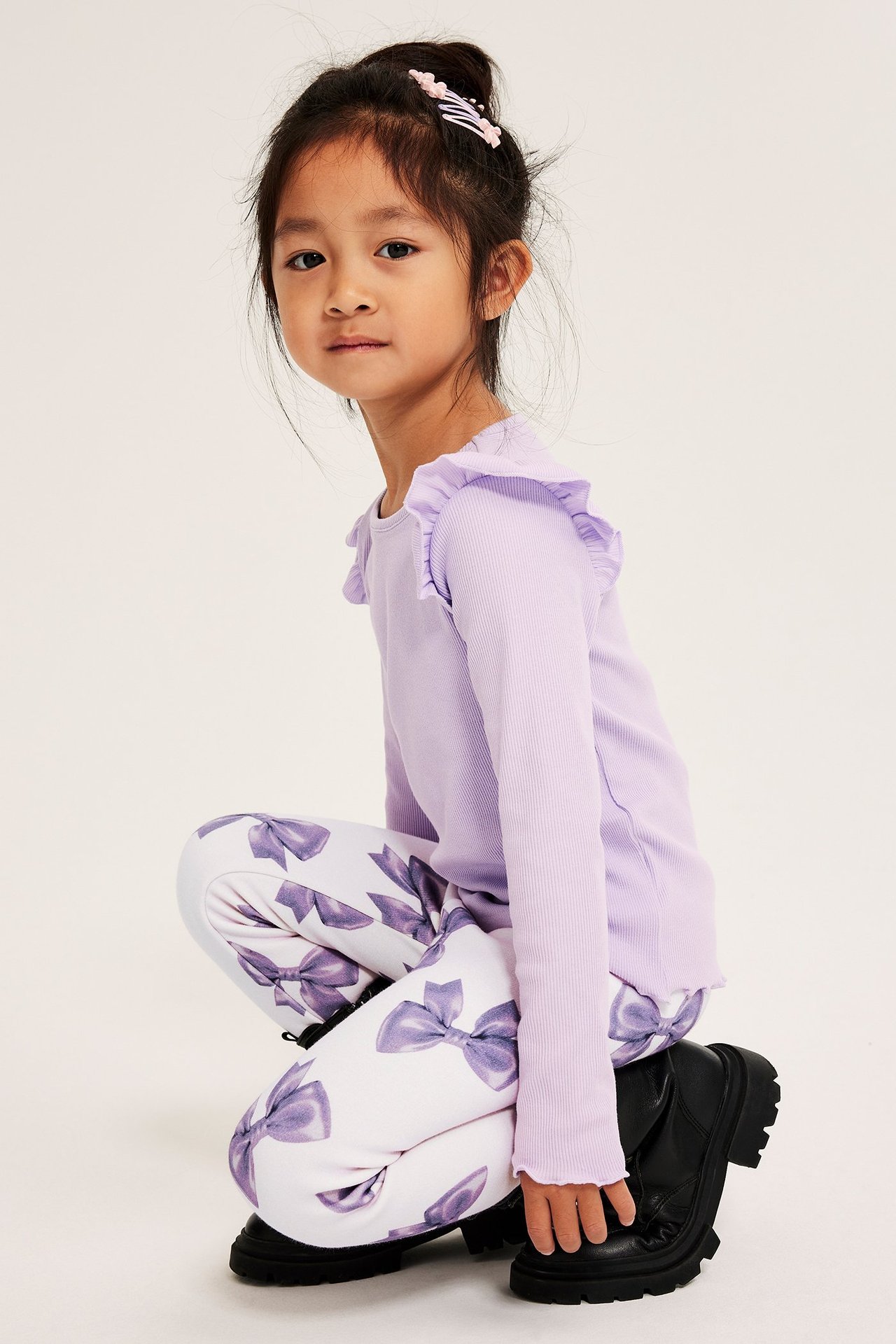 Vaaleanlilaiset lämpöleggingssit, tyttö käyttää niitä lilac-topin ja kuvioitujen legginsien kanssa.