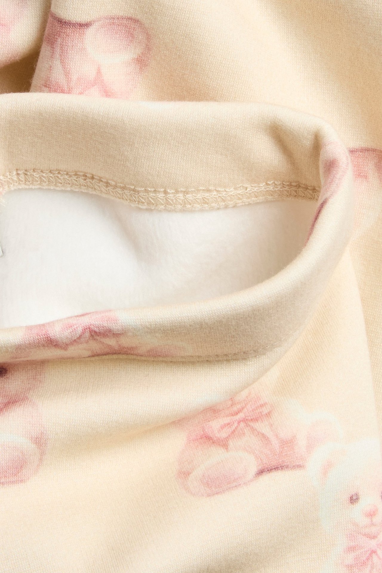 Ciepłe legginsy dla dzieci w jasnobeżowym kolorze, wzorzyste, miękka wewnętrzna strona.