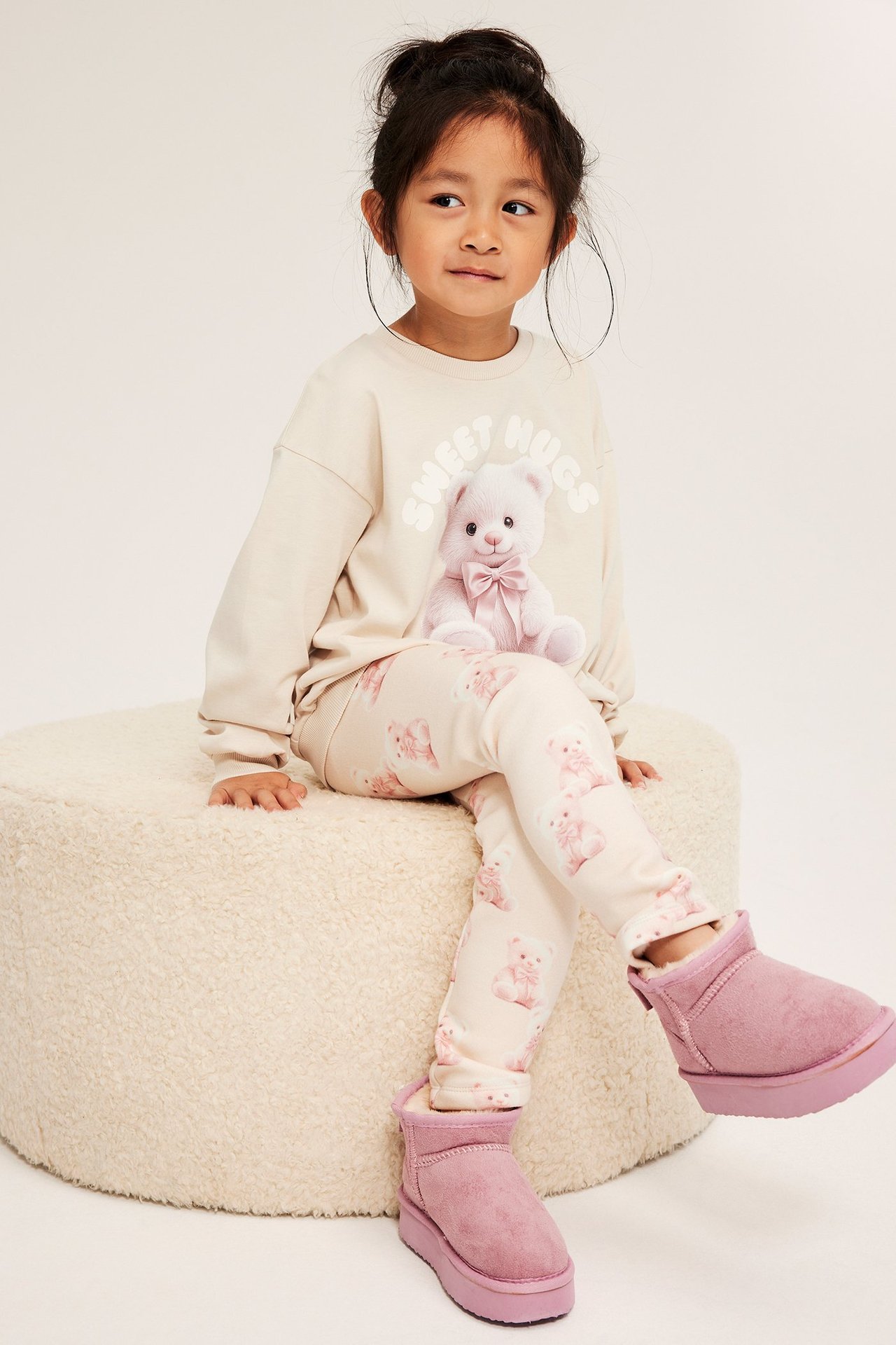 Vaaleanbeiget lämpöleggingsit kuviolla ja pehmeällä sisäpinnalla, tyttö, pitkähiha toppi, vaaleanpunaiset saappaat.