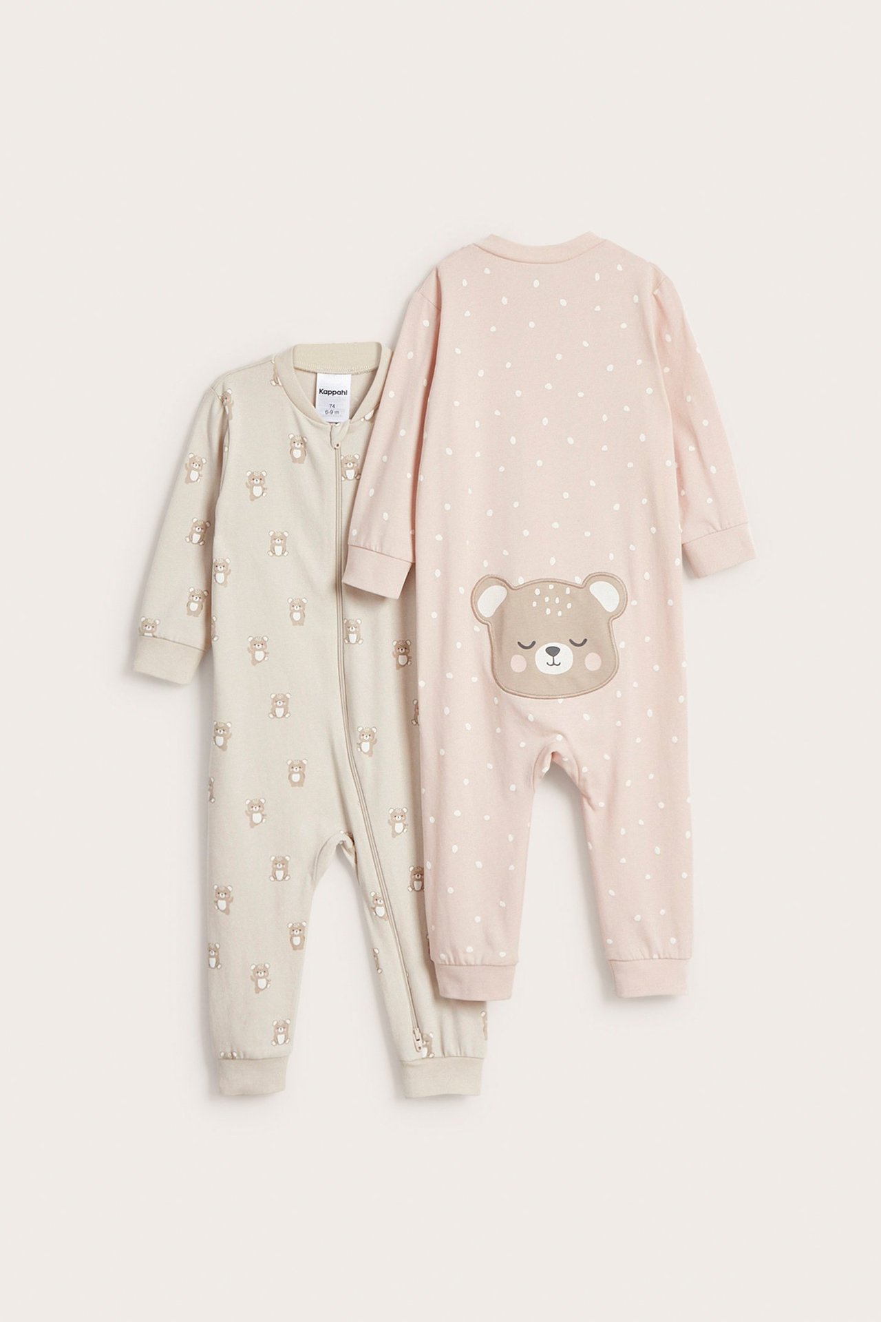 Widok z przodu: beżowy pajacyk niemowlęcy w misie, z zamkiem, obok różowy w kropki z aplikacją misia.