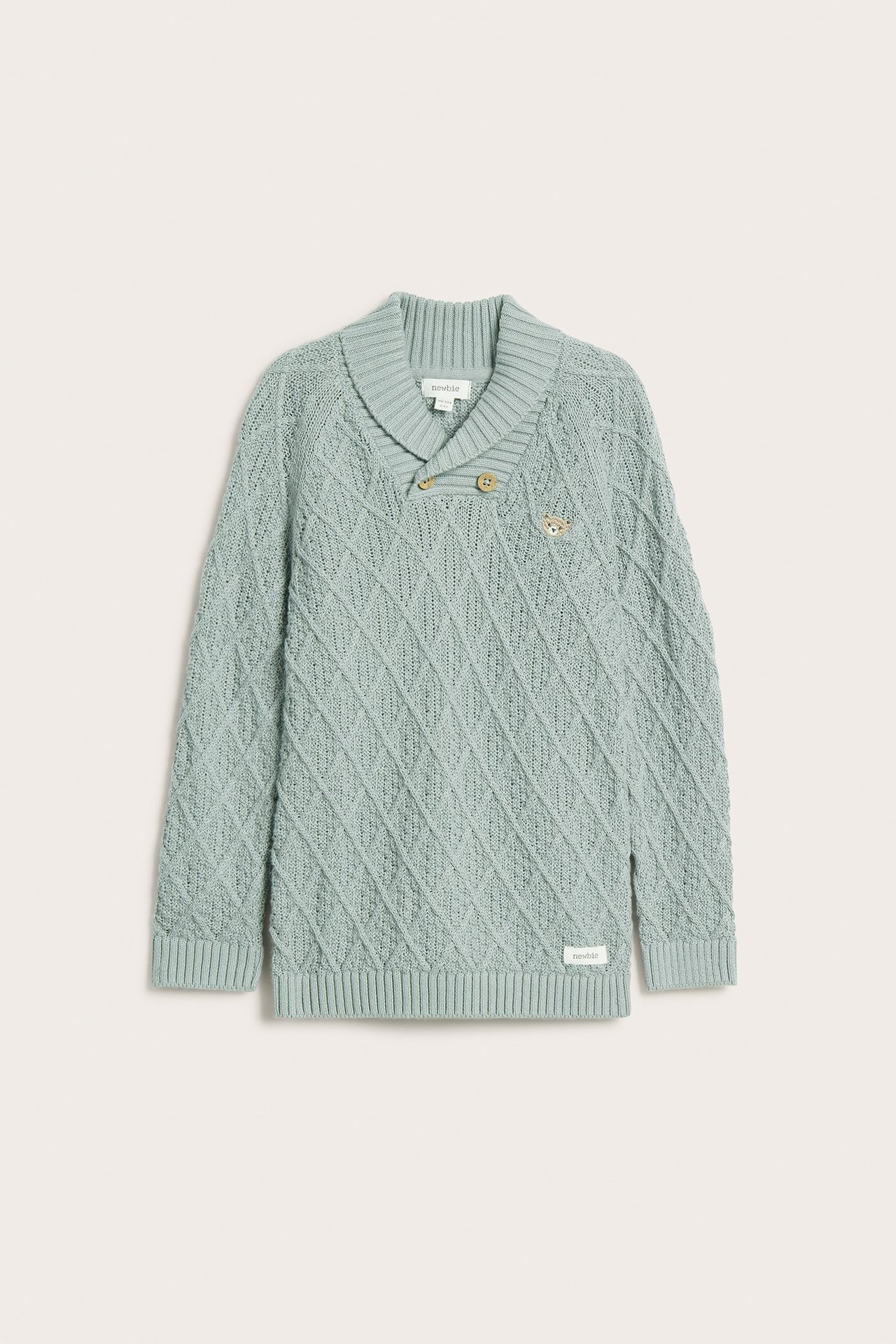 Edestä: Vaaleanvihreä neulottu puuvillapaita, jossa timanttikuvio, huivikaulus, puunapit ja nallebrodeeraus.