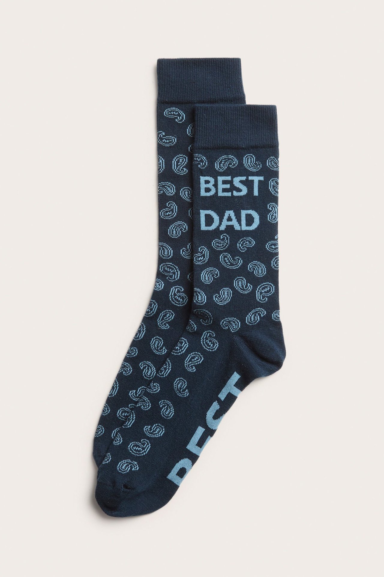 Framsida av ett par mörkblå herrstrumpor med ljusblått paisleymönster och texten 'BEST DAD'.