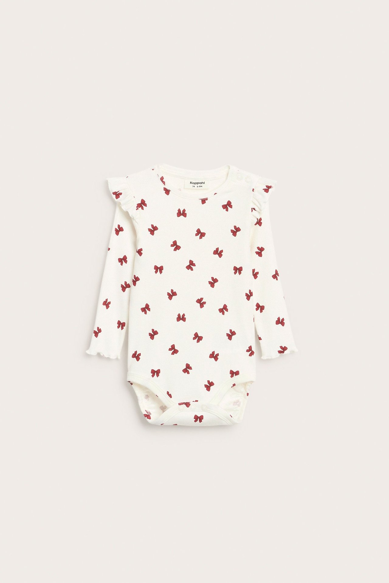 Frontvisning av offwhite ribbet babybody med rødt sløyfemønster, volanger på skuldrene og trykknapper.