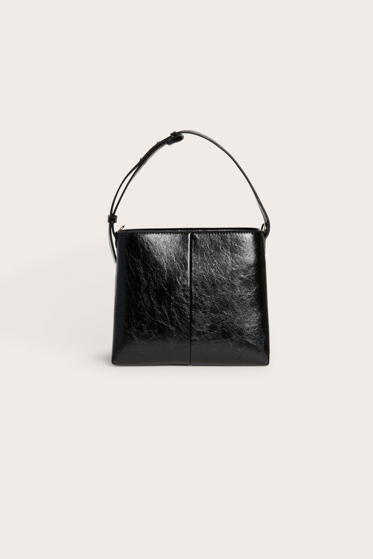 Edestä näkymä mustasta tekonahkaisesta käsilaukusta, jossa on lyhyt säädettävä olkahihna.