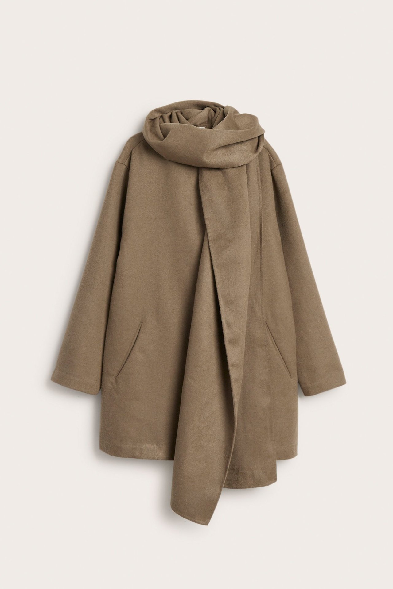 Edestä vaaleanruskea, villamainen takki laskostetulla irrotettavalla huivilla ja piilonapeilla.