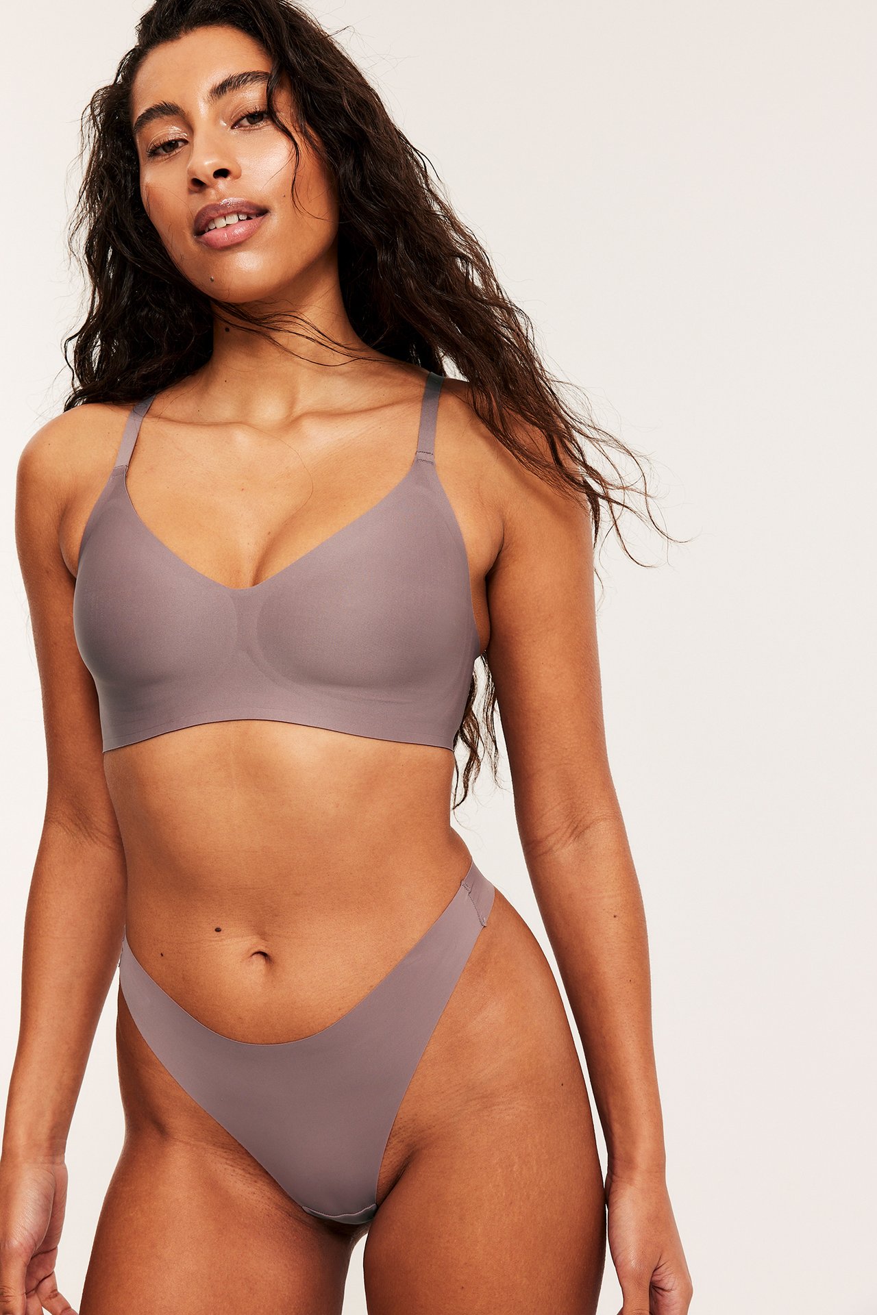 Frontvy av en kvinna i dunkelrosa, clean-cut micro stringtrosor och matchande bh.