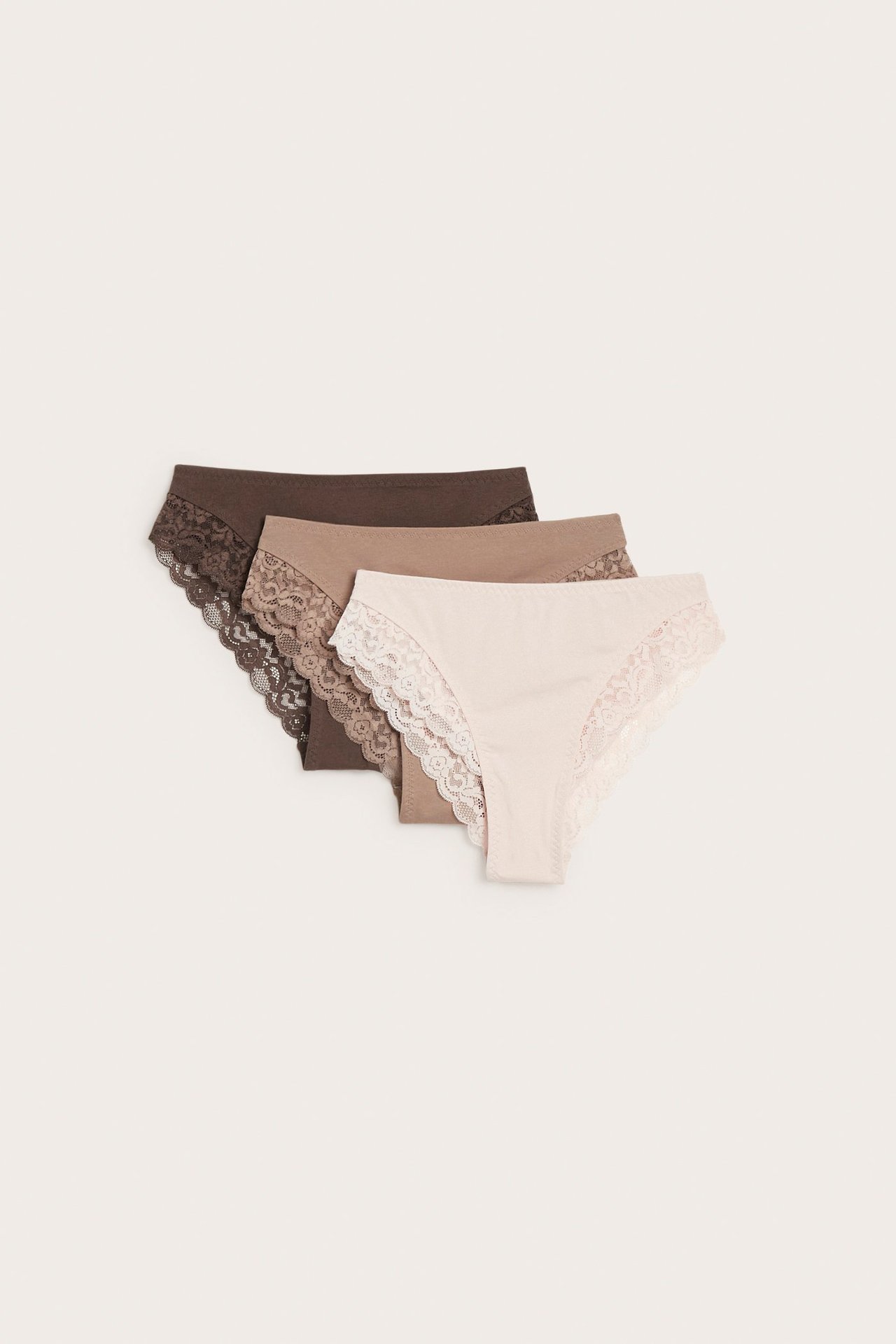Forfra: tre brazilian truser for dame i lys rosa, beige og mørk brun, med blonder.