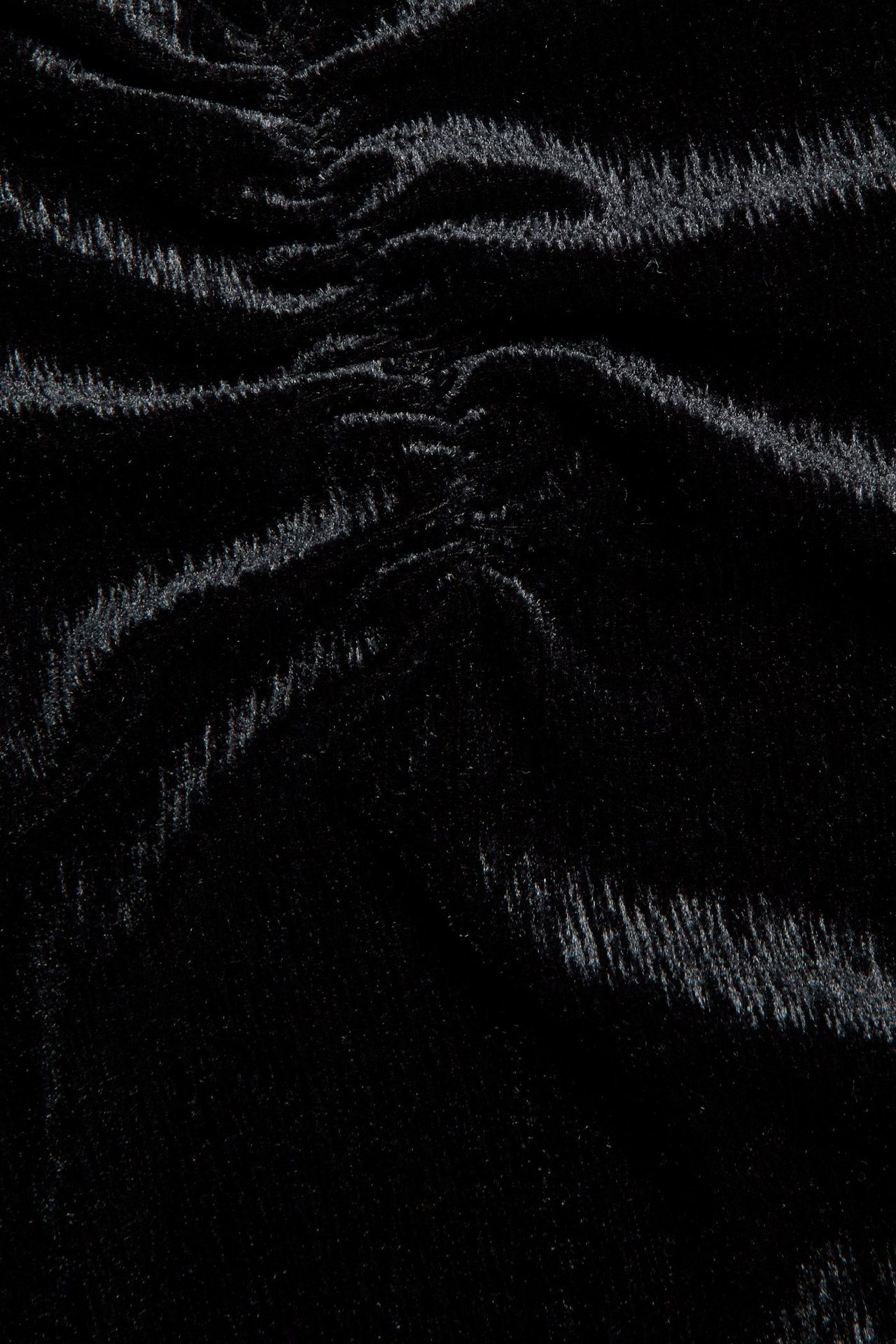 Zbliżenie czarnej welurowej bluzki z delikatnym marszczeniem.