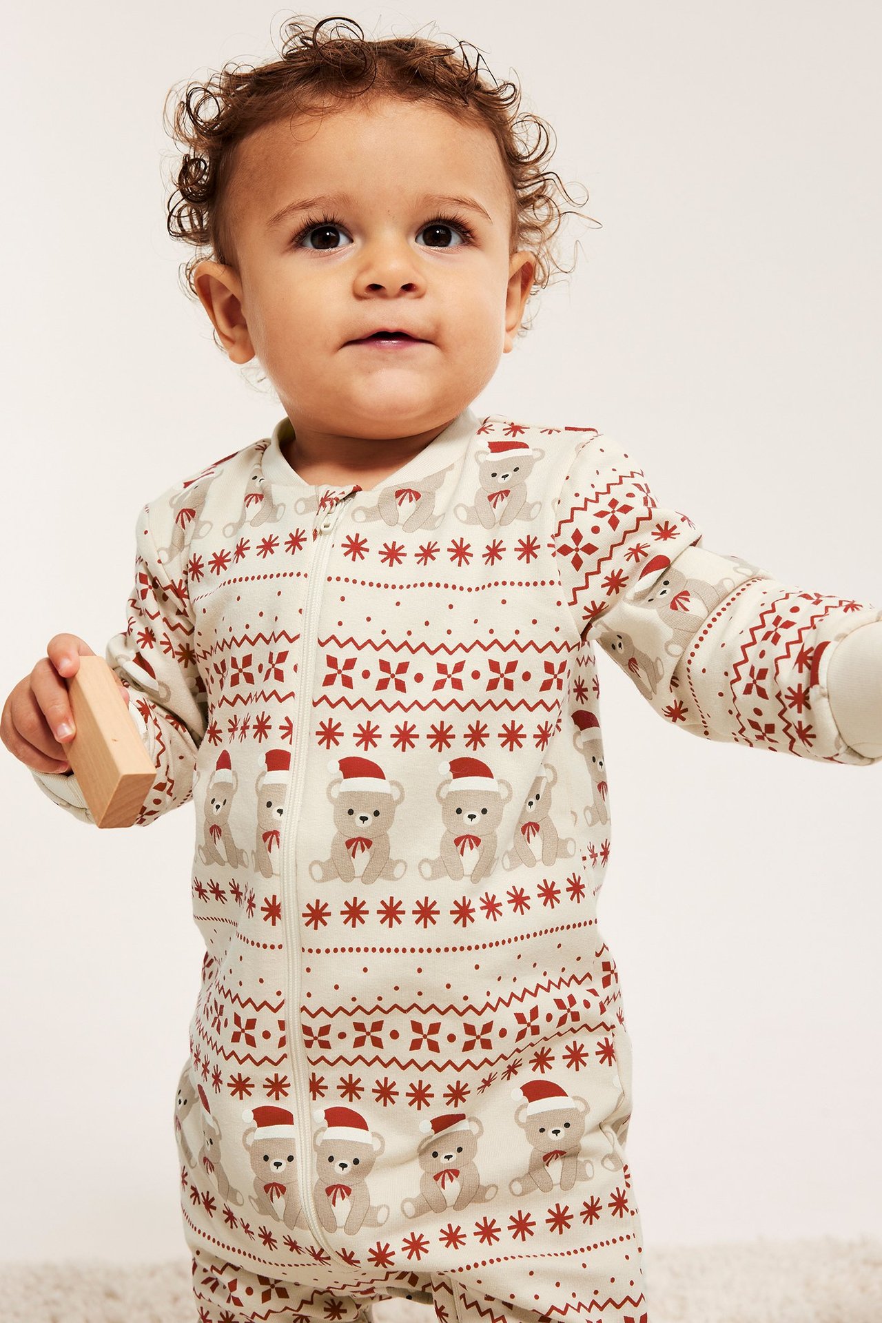 Barn i julemotiverte heldrakt med glidelås, mønstret, lys beige farge.