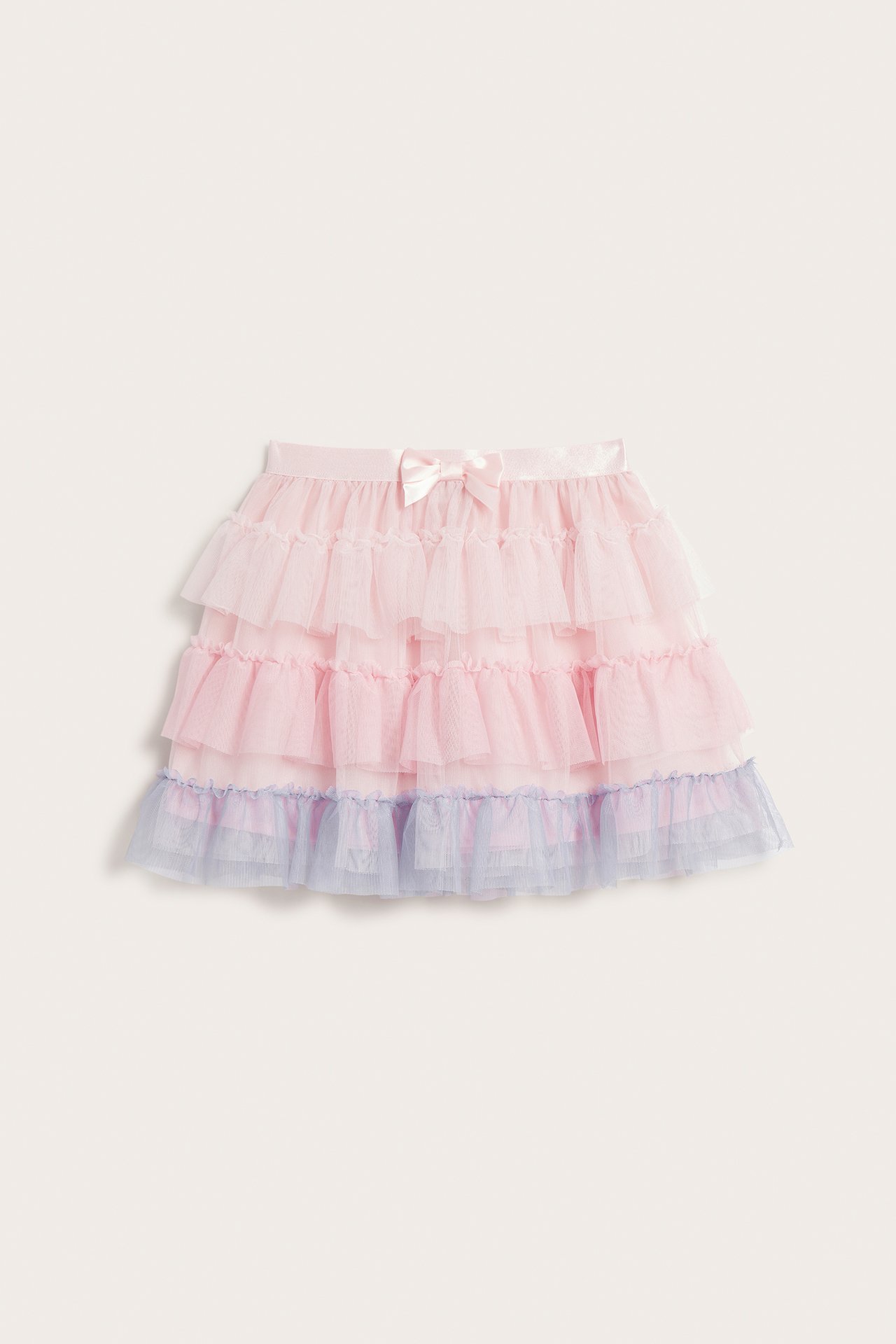 Widok z przodu jasnoróżowej spódnicy tiulowej dla dzieci z jasnoniebieską falbanką na dole i różową kokardką.