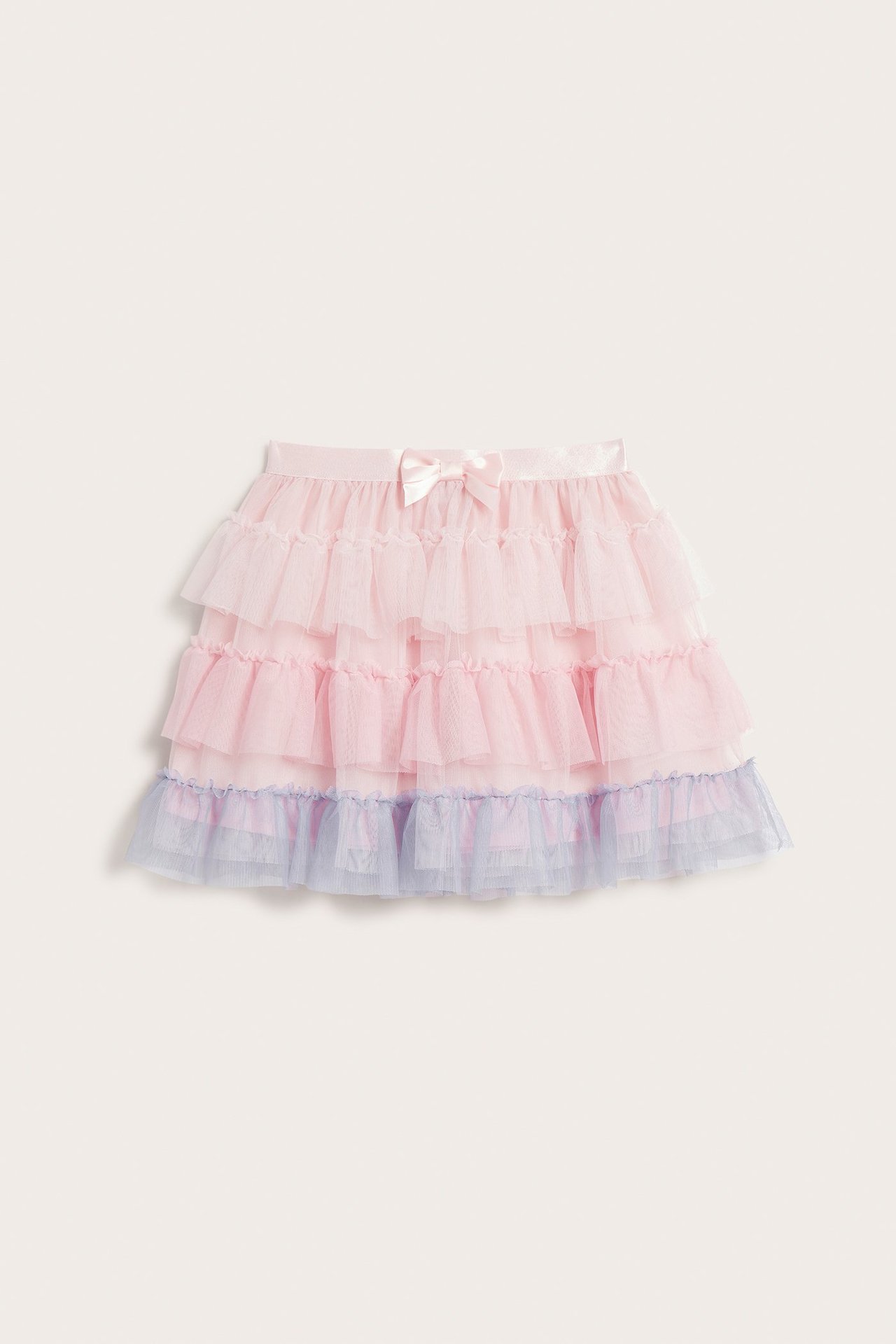 Widok z przodu jasnoróżowej spódnicy tiulowej dla dzieci z jasnoniebieską falbanką na dole i różową kokardką.