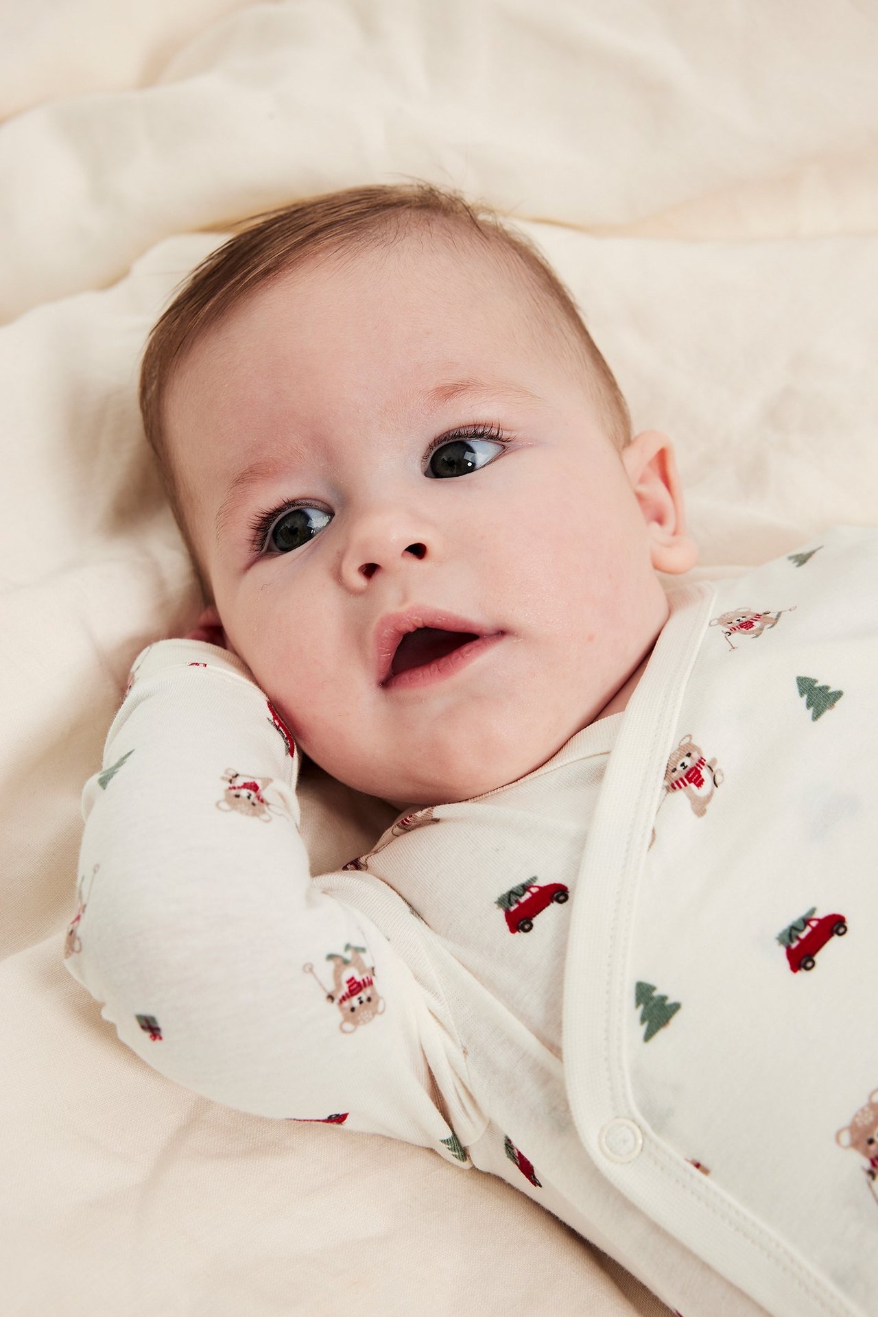 Baby i offwhite bodies med julmotiv, langermet, knapper ved skulderen, mønstret.