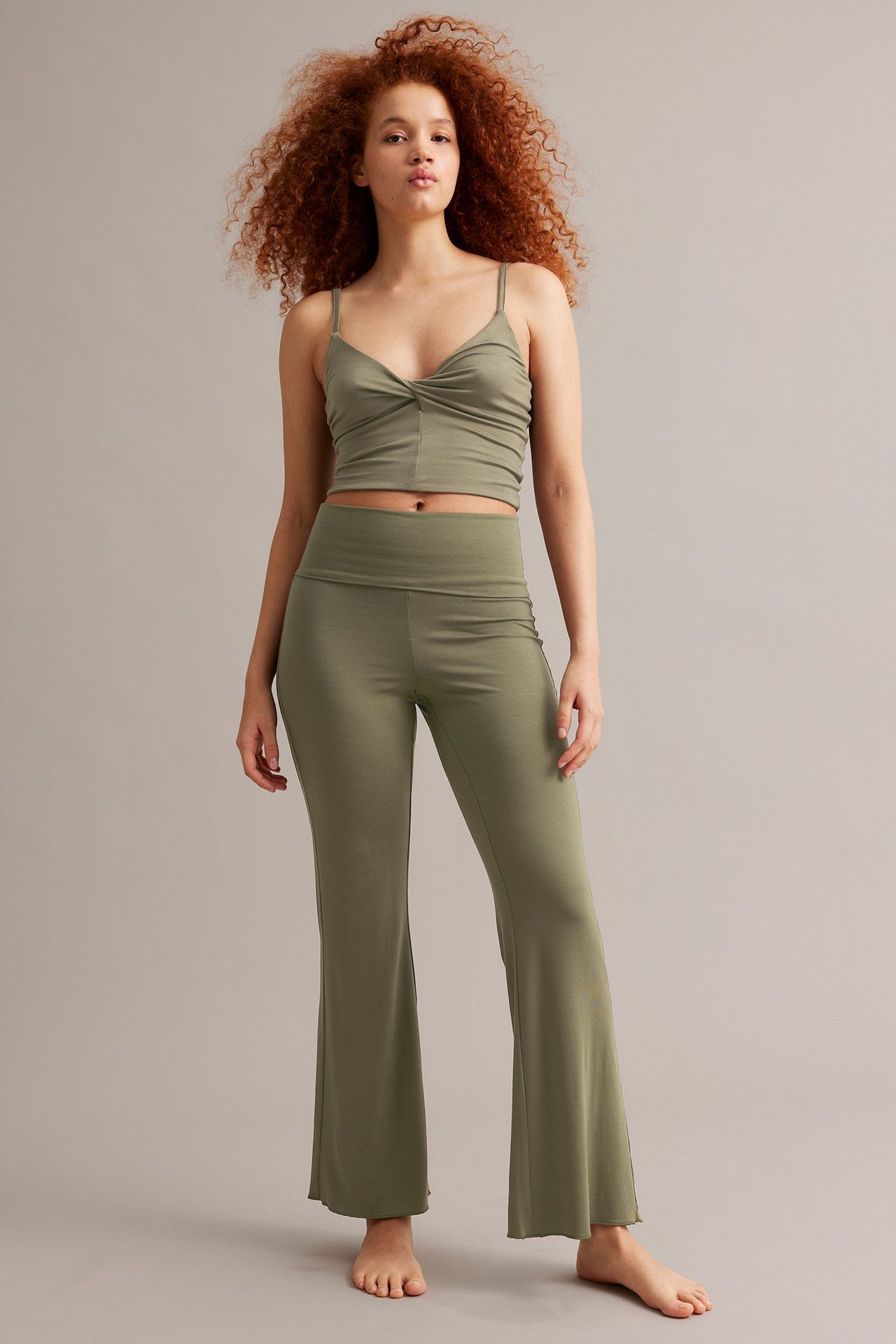 Forfra: Kvinne i khaki bootcut loungewearbukser og matchende kort camisole.