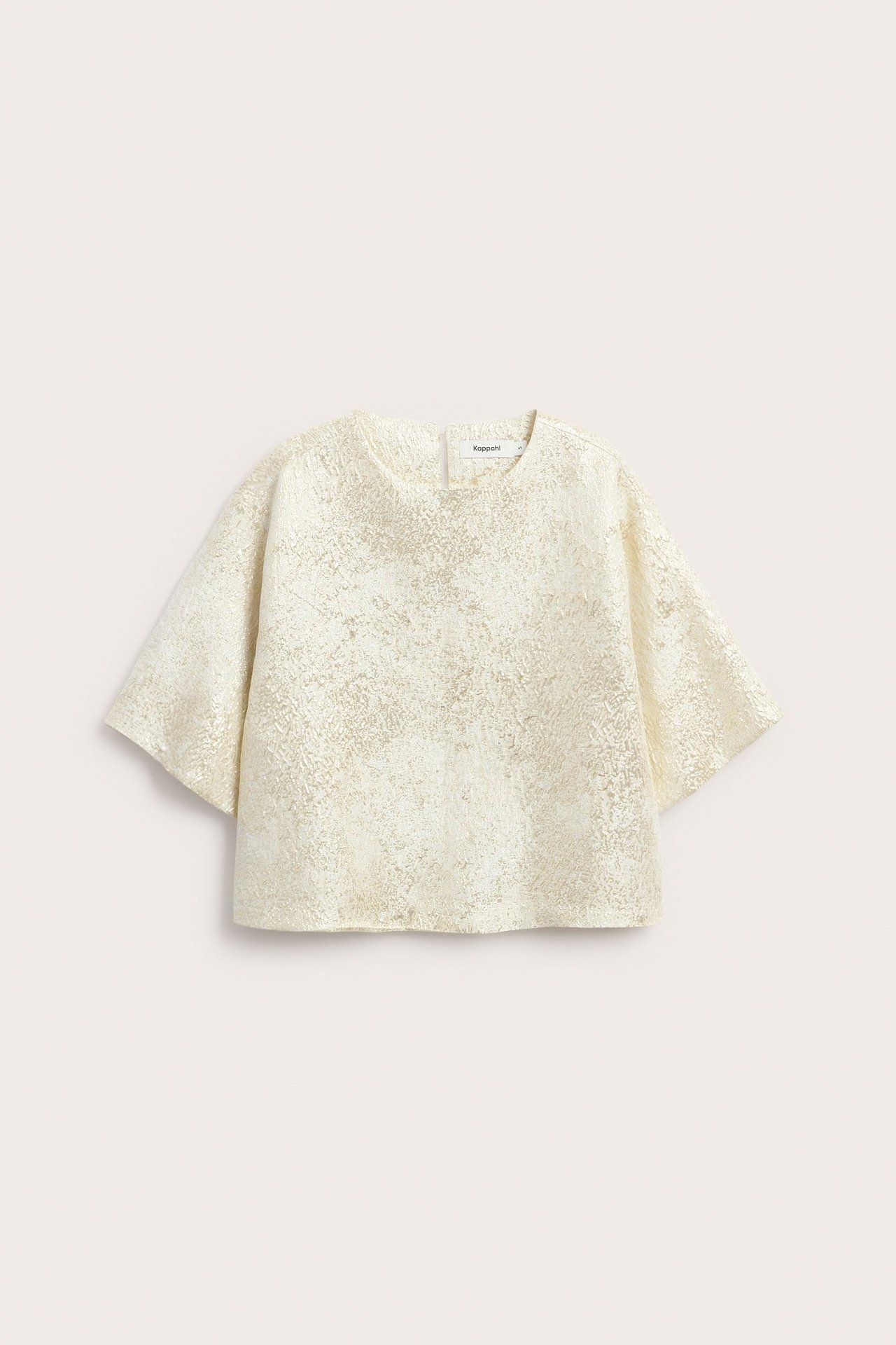 Forfra, offwhite brokadetopp med jacquardmønster og vide korte ermer.