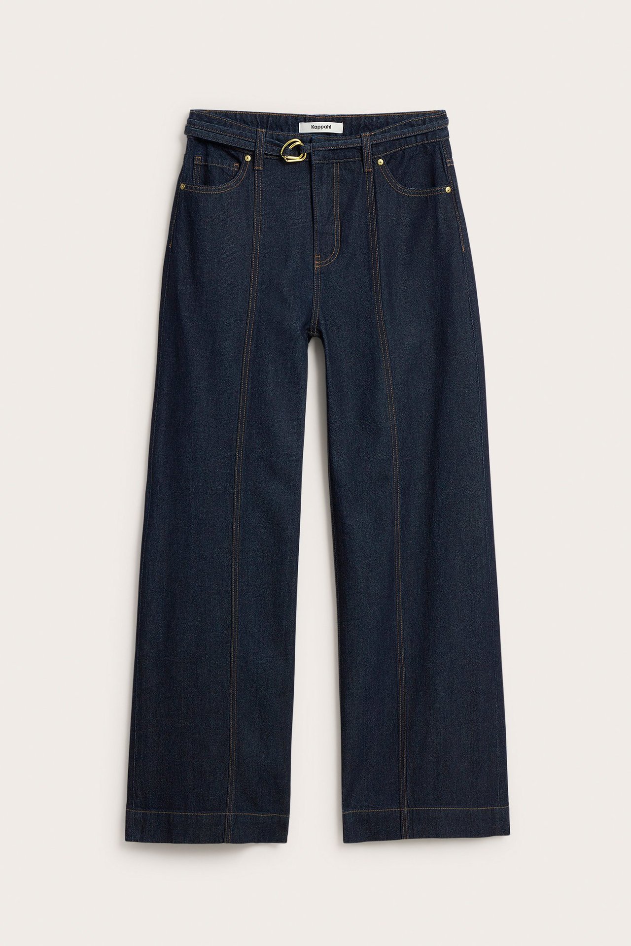Framsida av mörkblå vida jeans med söm längs benen och ett denimskärp med guldfärgat spänne.