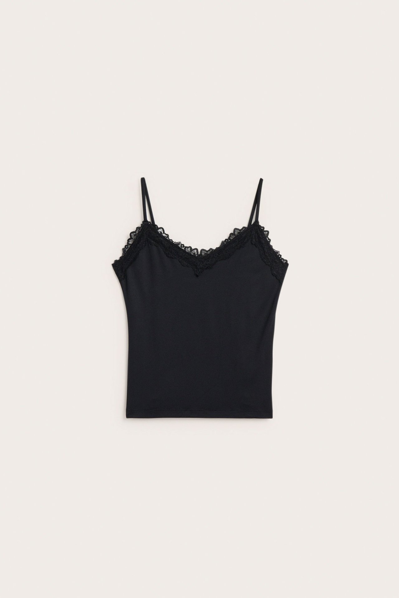 Forfra, svart kroppsnær singlet med tynne stropper og delikat blondekant i halsutringningen.