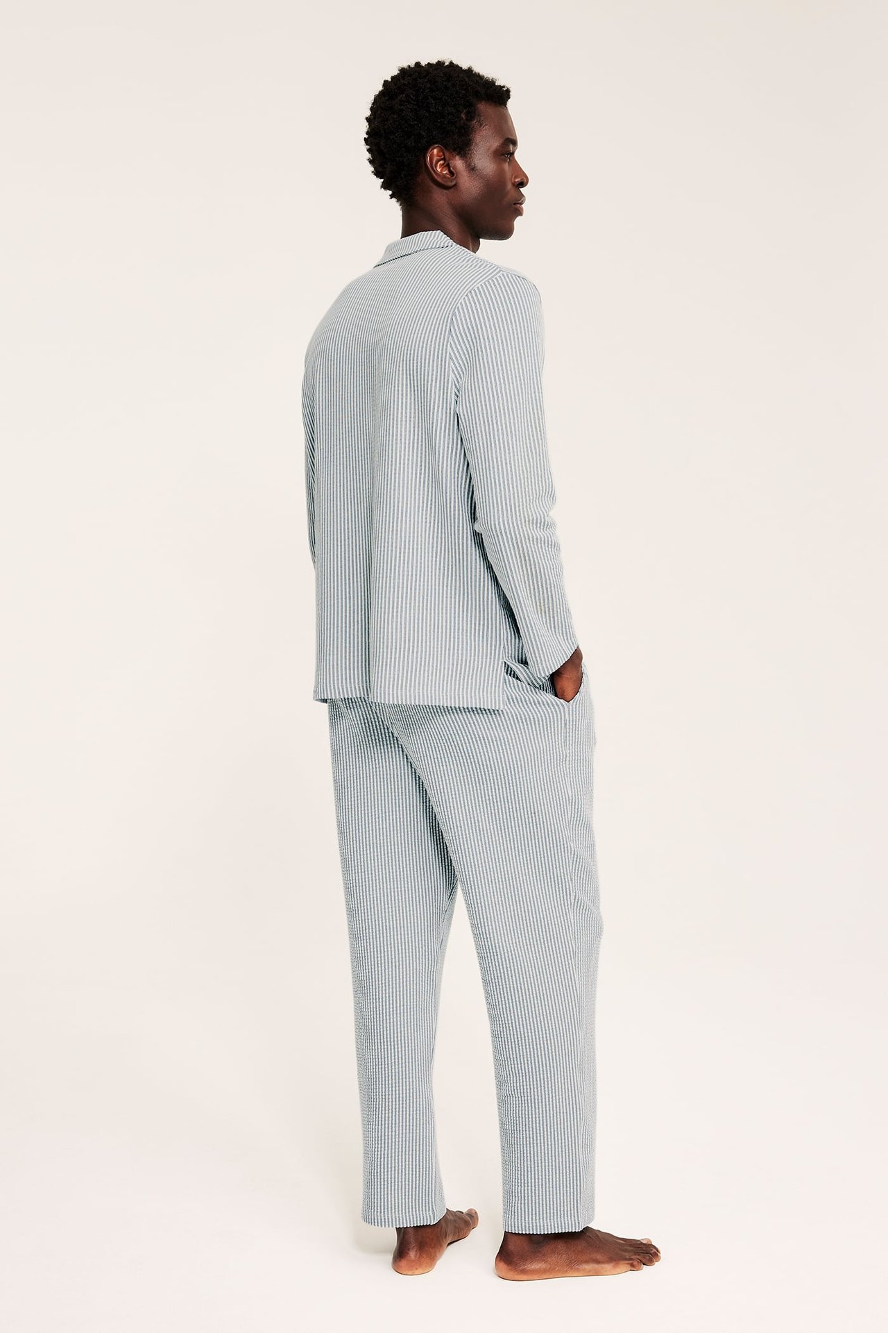 Side-bakfra visning av en mann i blå og hvitstripet seersucker pyjamas.