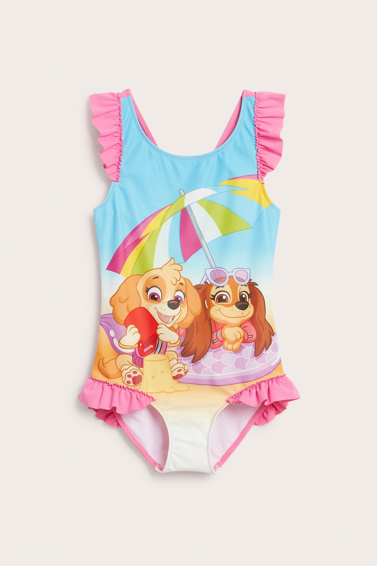 Edestä päin: lasten sininen uimapuku vaaleanpunaisilla röyhelöillä ja Ryhmä Hau -rantaprintillä.