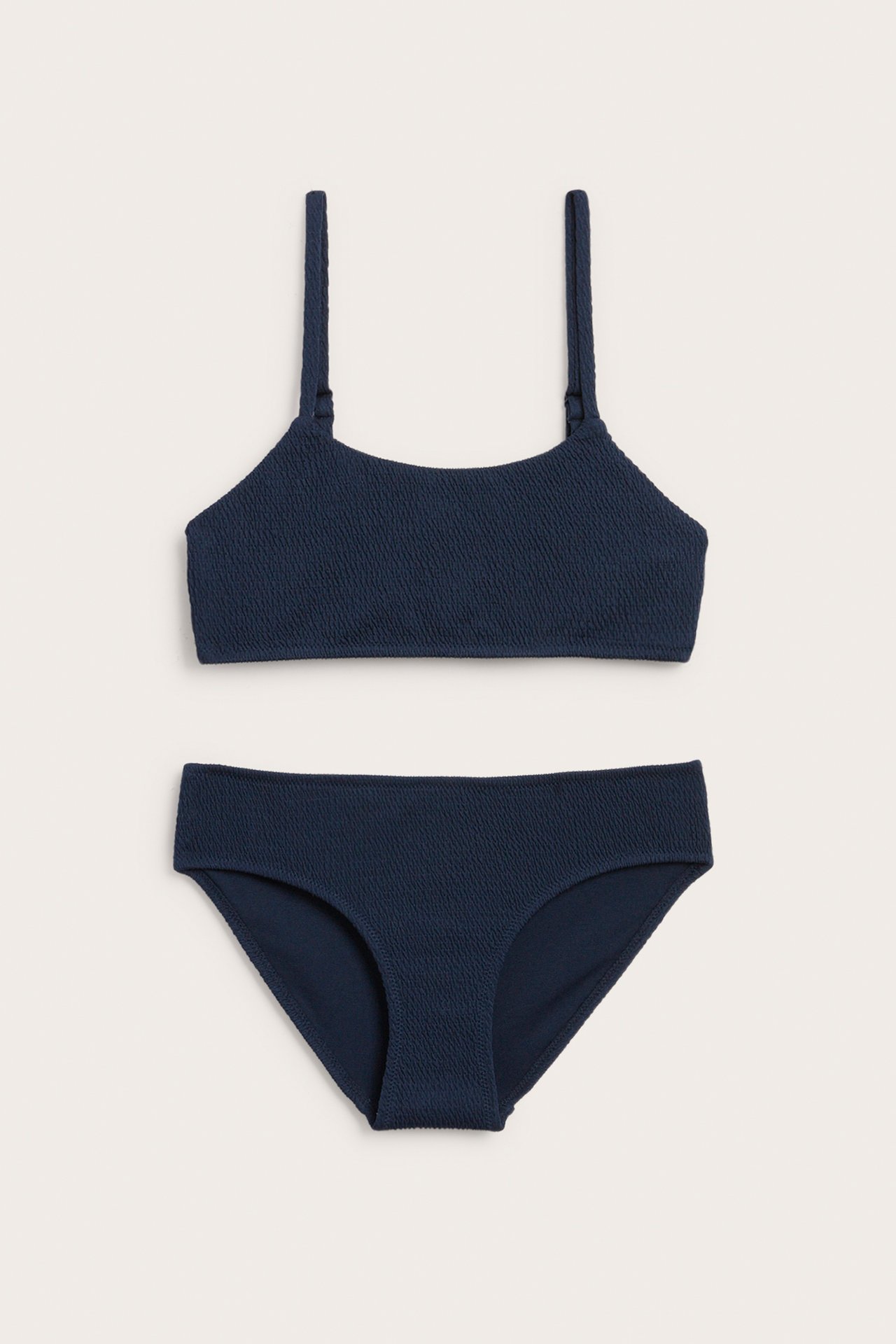Edestä tummansininen smockattu bikinisetti, jossa säädettävä olkaintoppi ja klassiset alaosat.