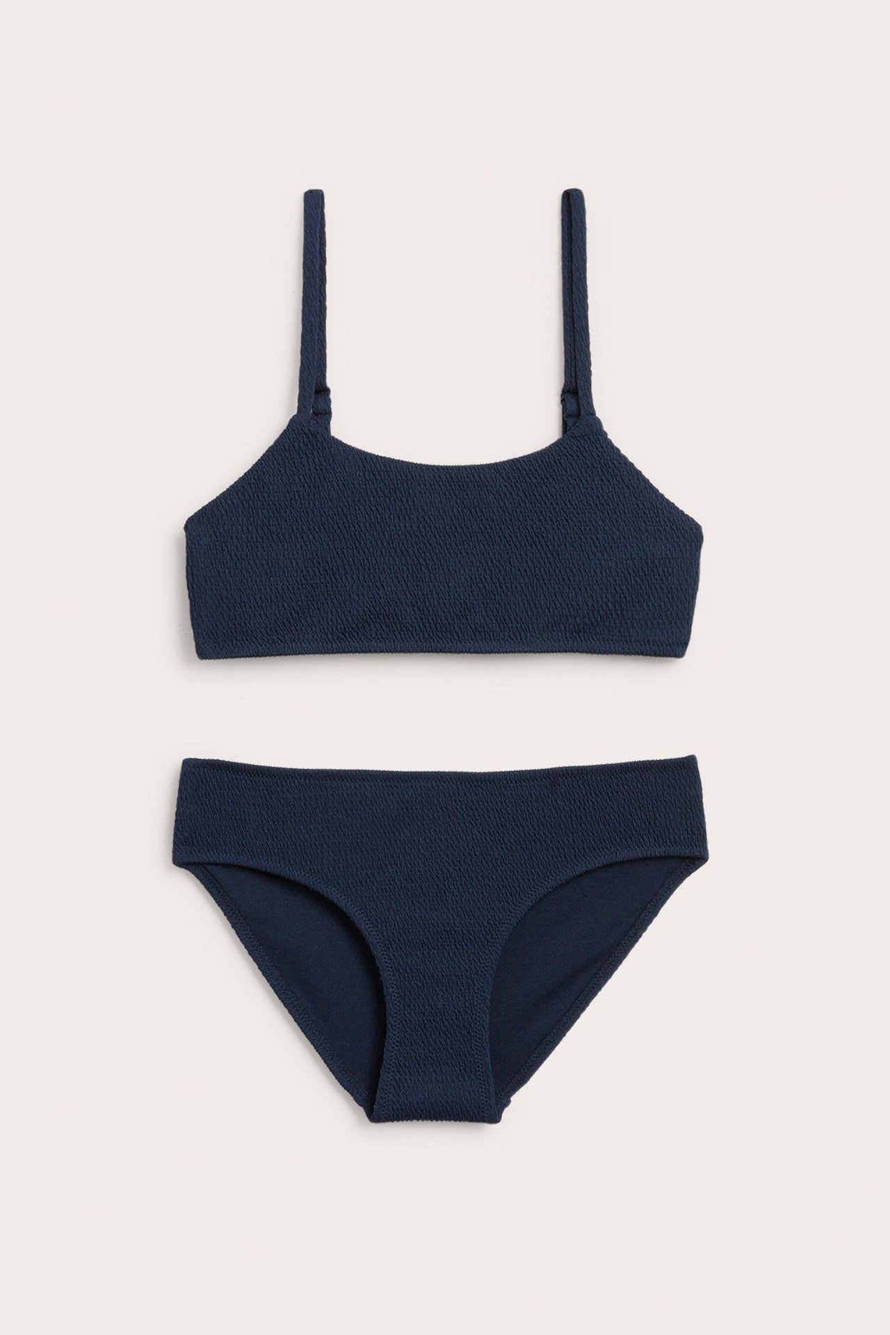 Edestä tummansininen smockattu bikinisetti, jossa säädettävä olkaintoppi ja klassiset alaosat.